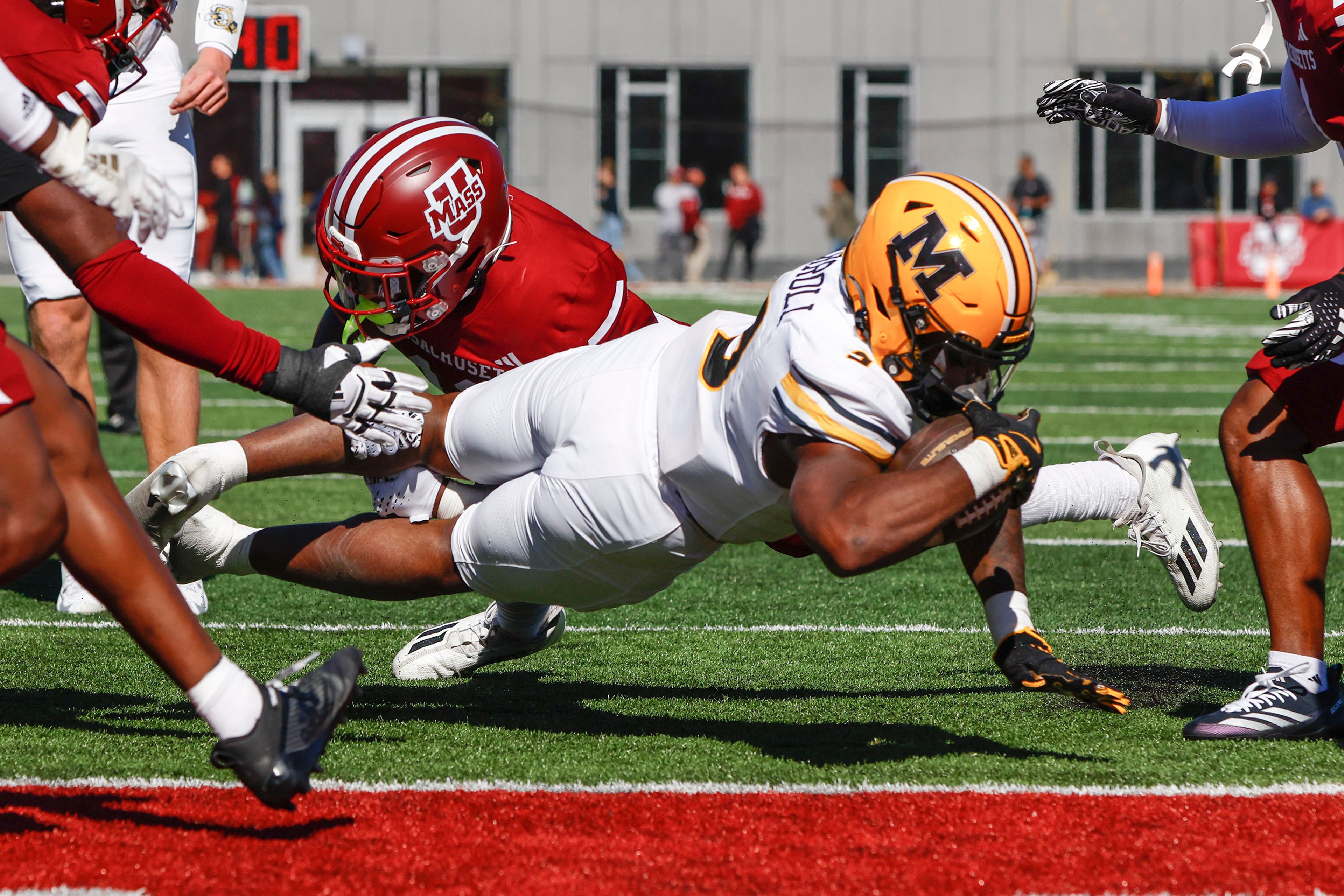 Missouri running back Marcus Carroll (9) dives for a touchdown while tackled by Massachusetts defensive back Leonard St. Gourdin (11) during the first half of an NCAA football game on Saturday, Oct. 12, 2024, in Amherst, Mass. (AP Photo/Greg M. Cooper)