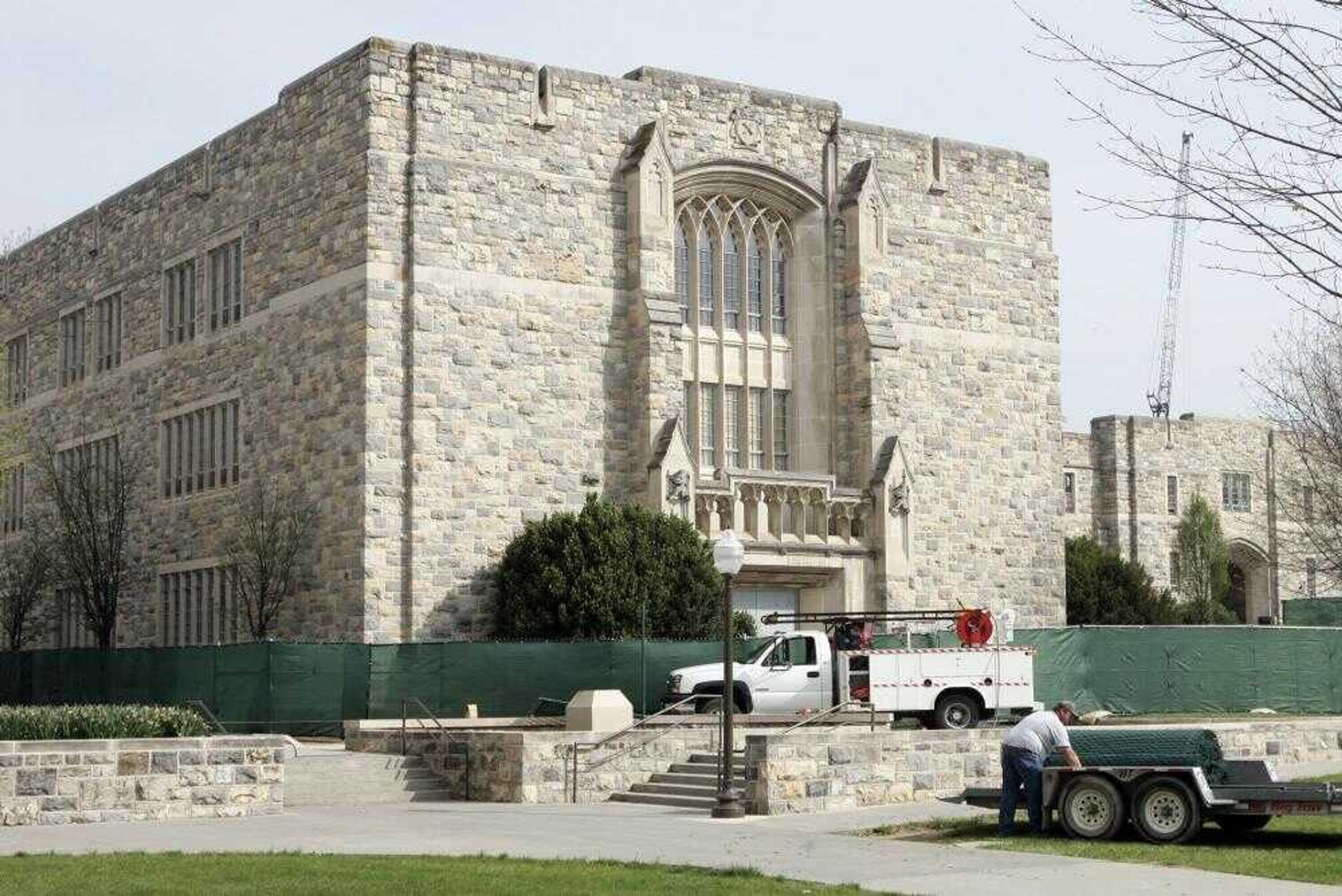 Workers put a fence around Norris Hall on April 25 on the Virginia Tech campus in Blacksburg, Va. Norris Hall, the classroom building where a gunman killed 30 people and himself April 16, will be reopened for offices and laboratories later this month, the university announced Tuesday. (Evan Vucci ~ Associated Press)