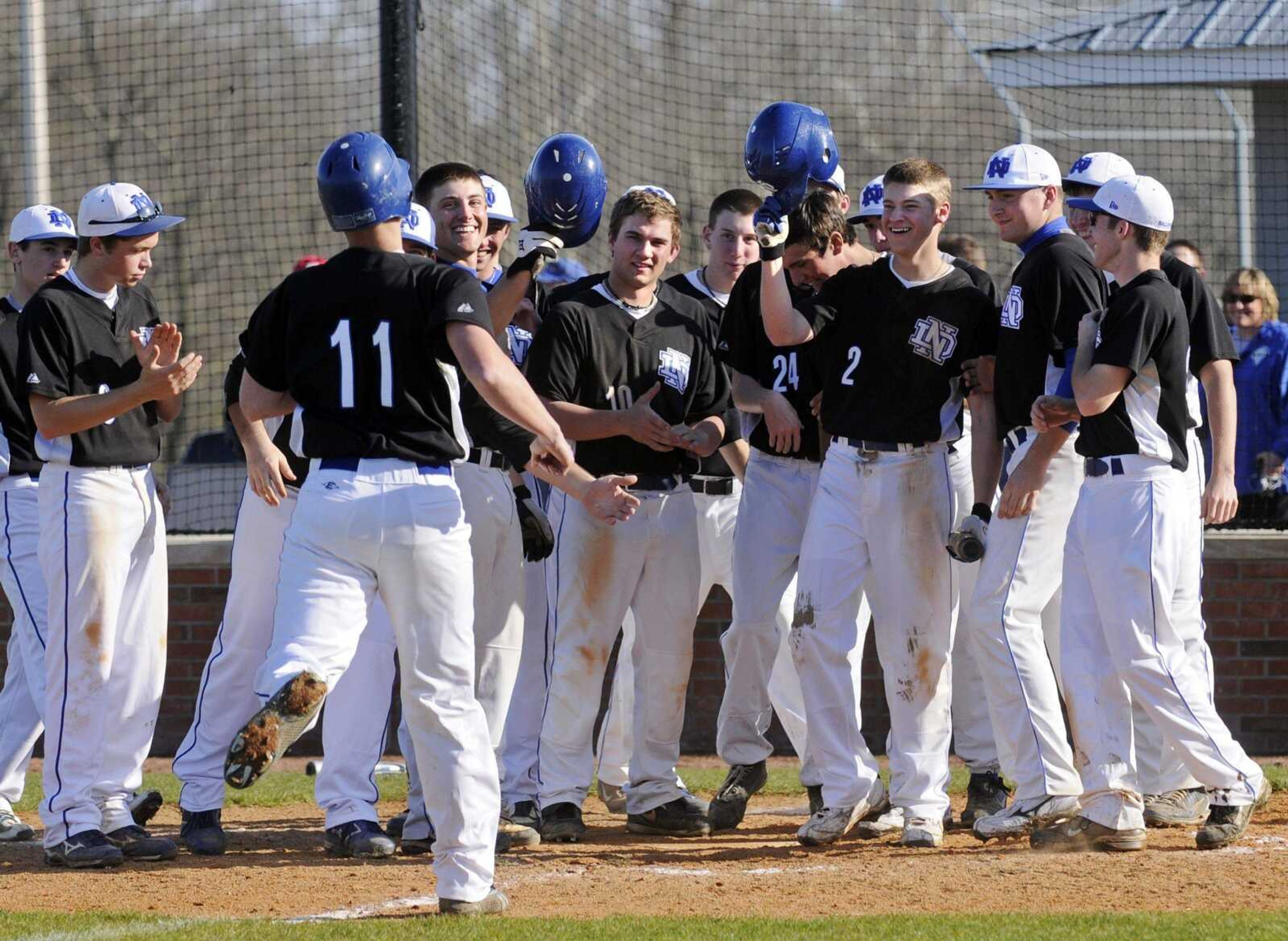 Notre Dame players gather at home plate to greet Mark Hagedorn after his fourth-inning home run against Perryville on Tuesday at Notre Dame Regional High School. Notre Dame won 14-1. (KRISTIN EBERTS)