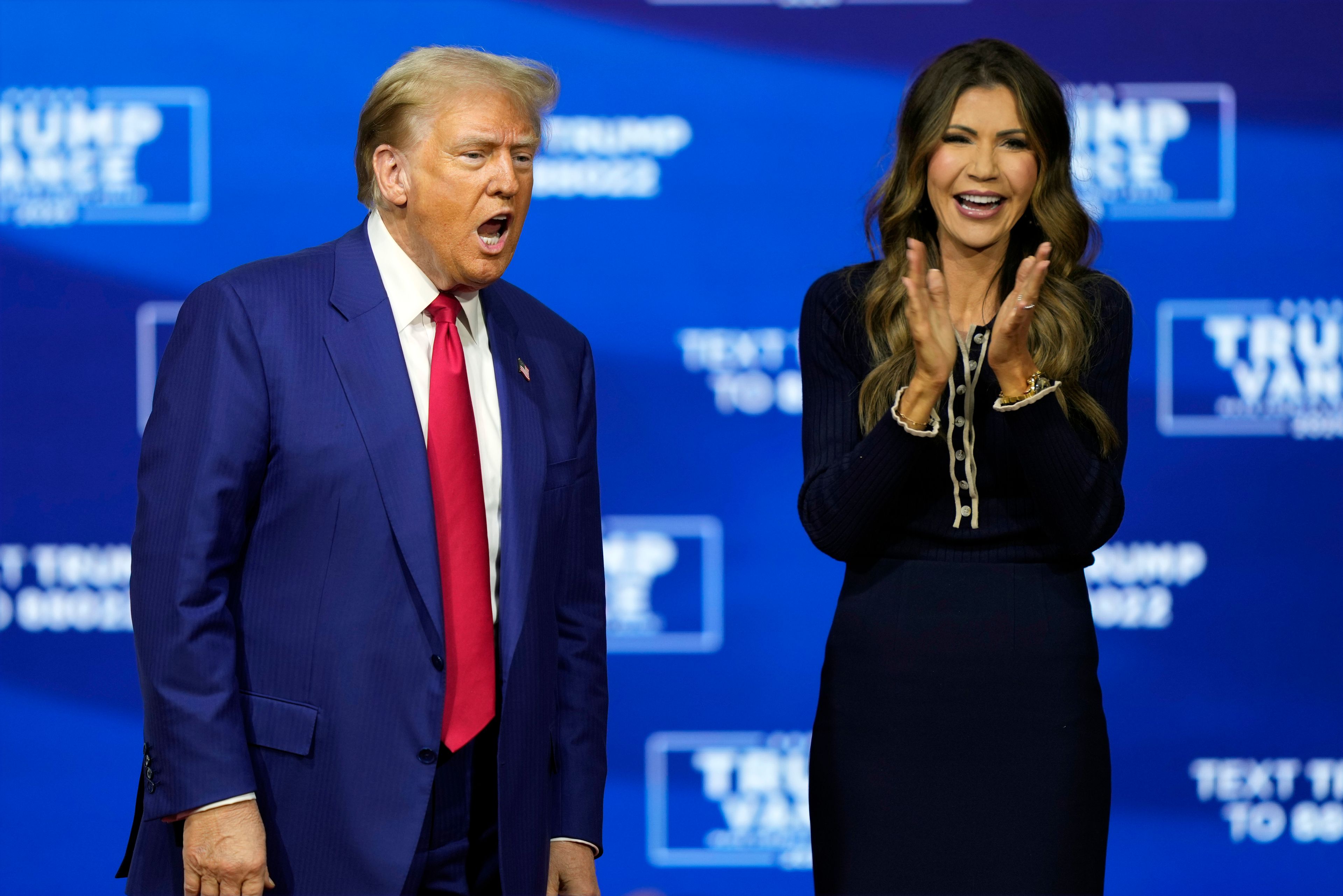 Republican presidential nominee former President Donald Trump arrives at a campaign town hall at the Greater Philadelphia Expo Center & Fairgrounds, Monday, Oct. 14, 2024, in Oaks, Pa., as moderator South Dakota Gov. Kristi Noem watches. (AP Photo/Matt Rourke)