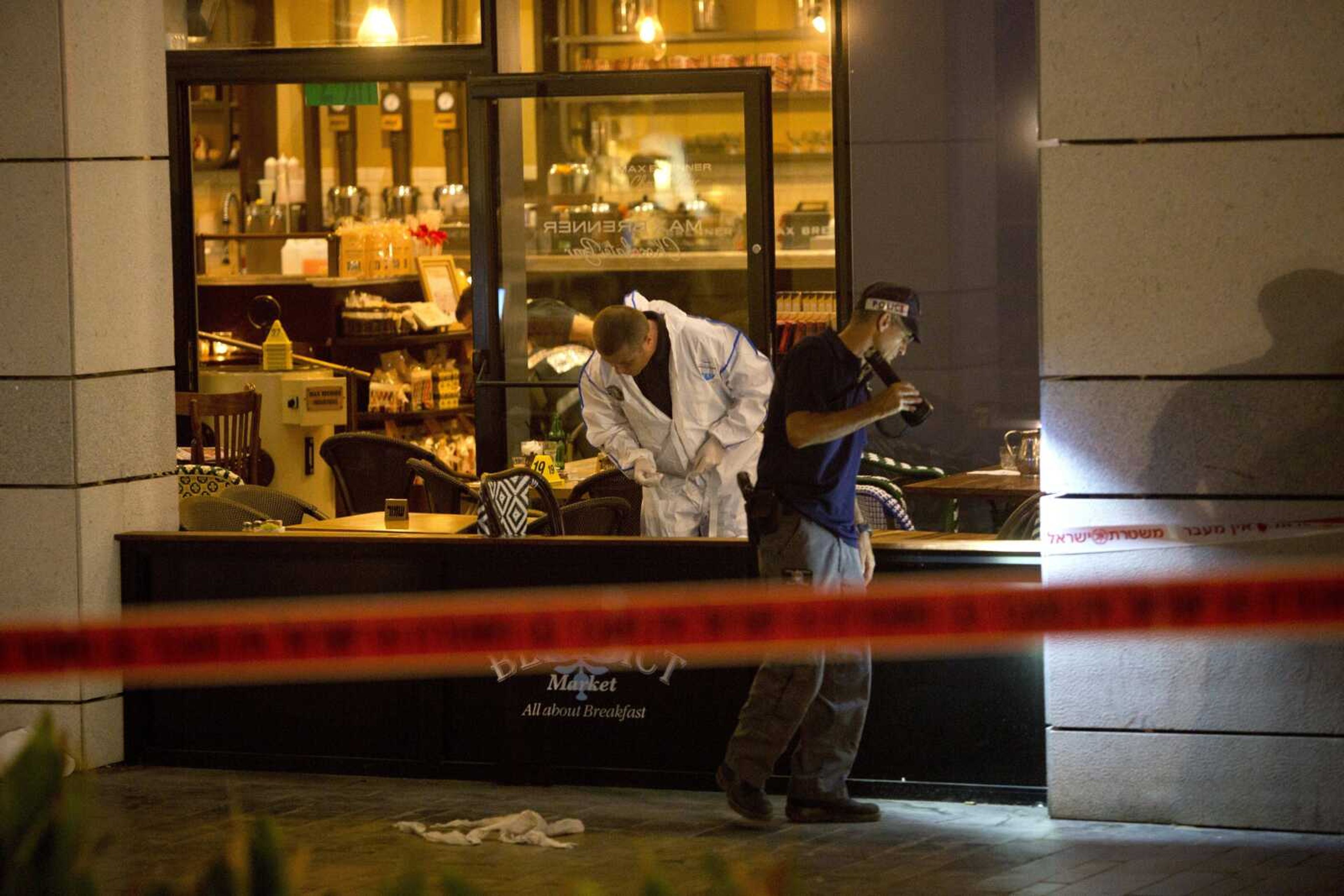 Israeli police officers examine the scene of a shooting attack Wednesday in Tel Aviv, Israel.