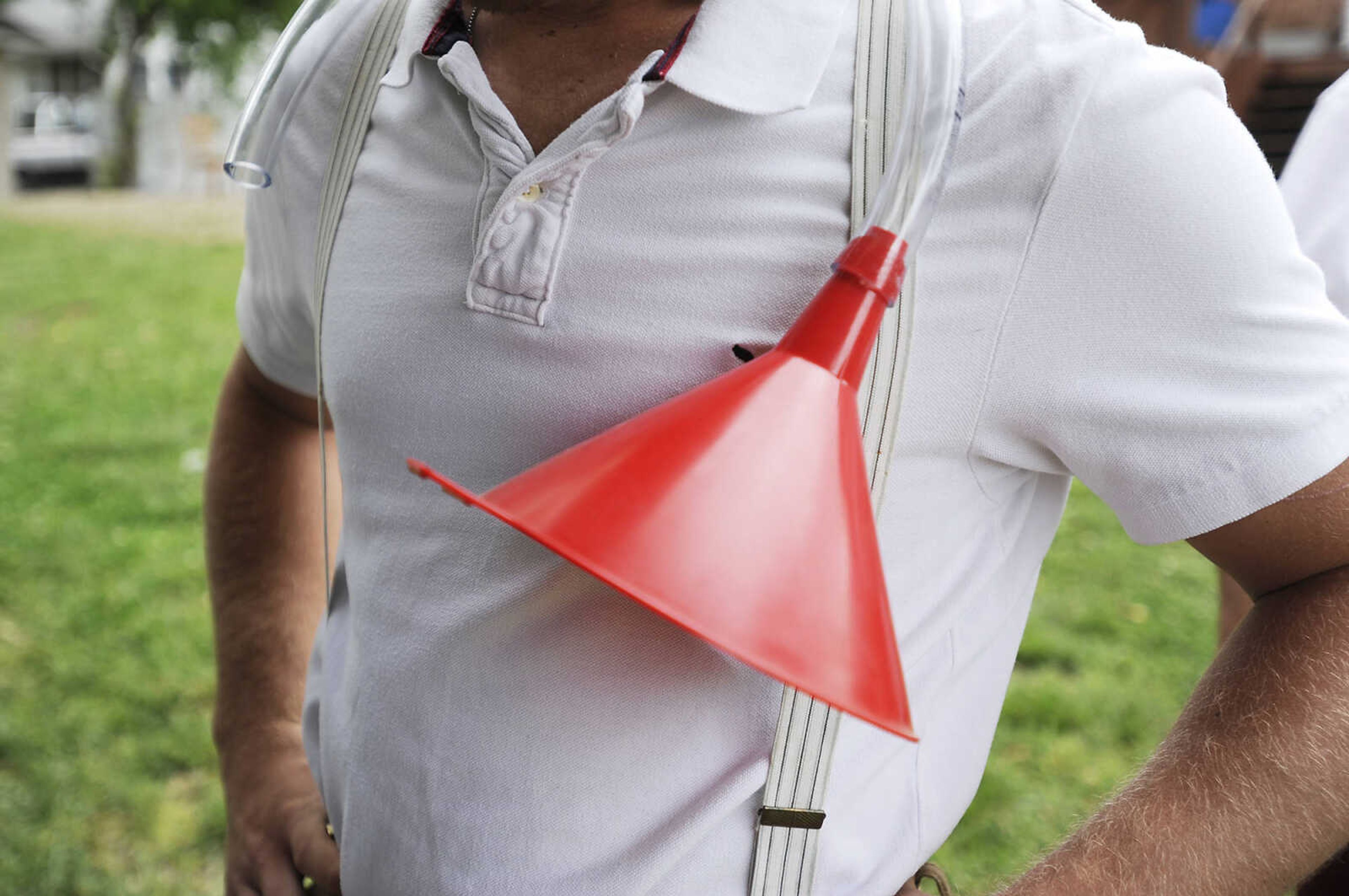 Zach Essner stands with a beer funnel wrapped around his neck behind Schindler's Tavern in New Hamburg during the Kow Pasture Klassic Saturday, April 28. Teams play a nine-hole course laid out in a pasture behind the tavern using tennis balls and a variety of objects as clubs, including tennis rackets, oars and mallets.