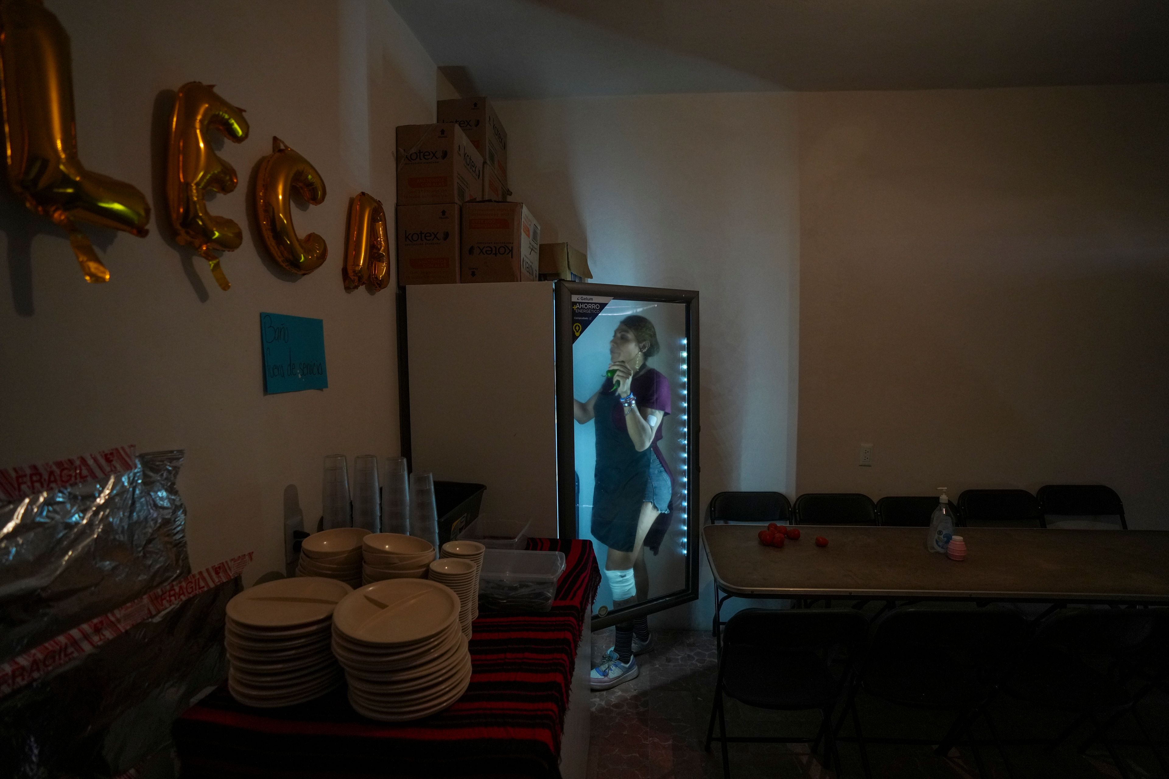 Karolina Long Tain González Rodríguez, a trans woman, retrieves ingredients from a refrigerator before opening the community kitchen at Casa Lleca, an LGBTQ+ shelter in the Peralvillo neighborhood of Mexico City, Friday, Sept. 20, 2024. (AP Photo/Fernando Llano)