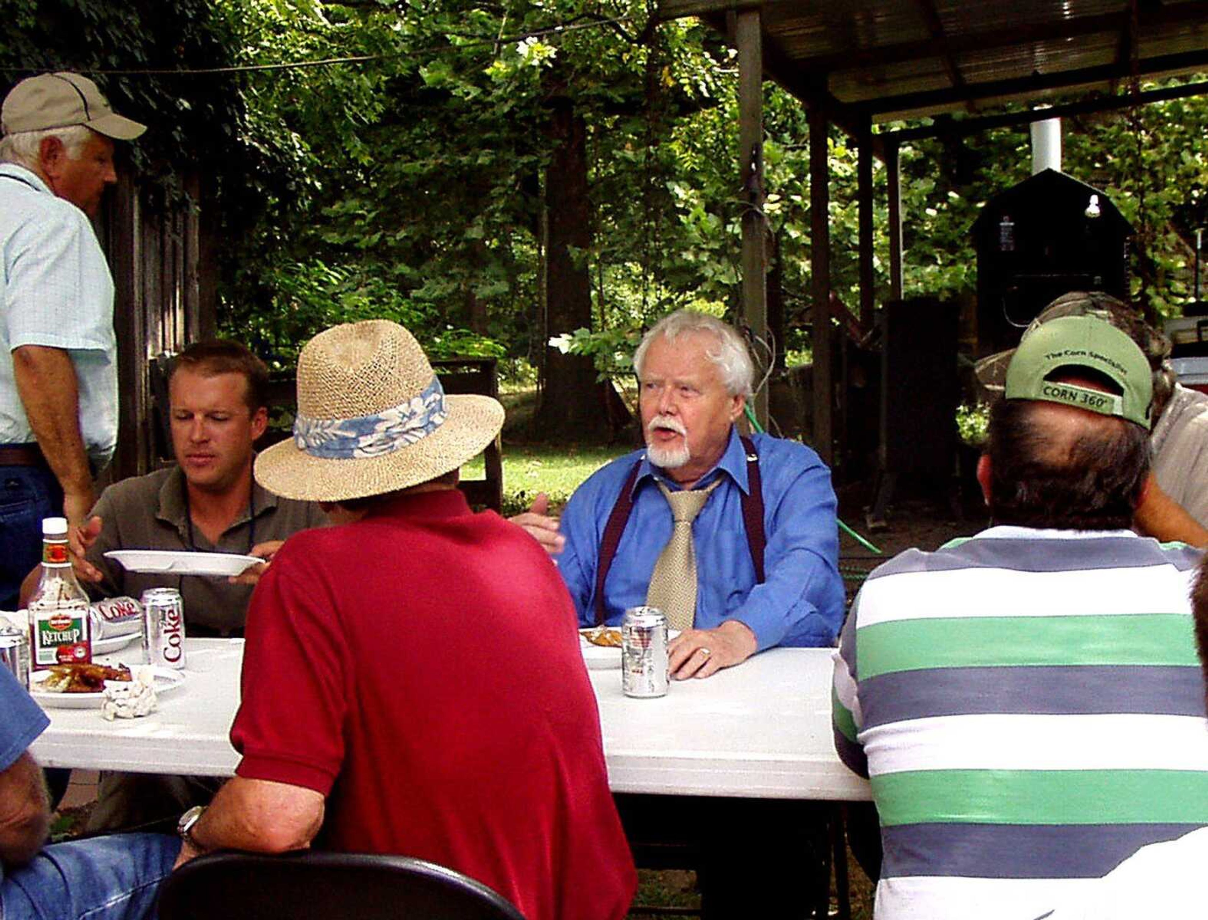 Liz Anderson/ENTERPRISE-COURIER
John Gustavson, center, geologist and owner of Water Research & Development, meets with landowners at a fish fry at Wanda and Milus Gary Wallace's residence August 19. Gustavson has been talking with private landowners trying to obtain permission to drill water wells to search for uranium in Mississippi County.