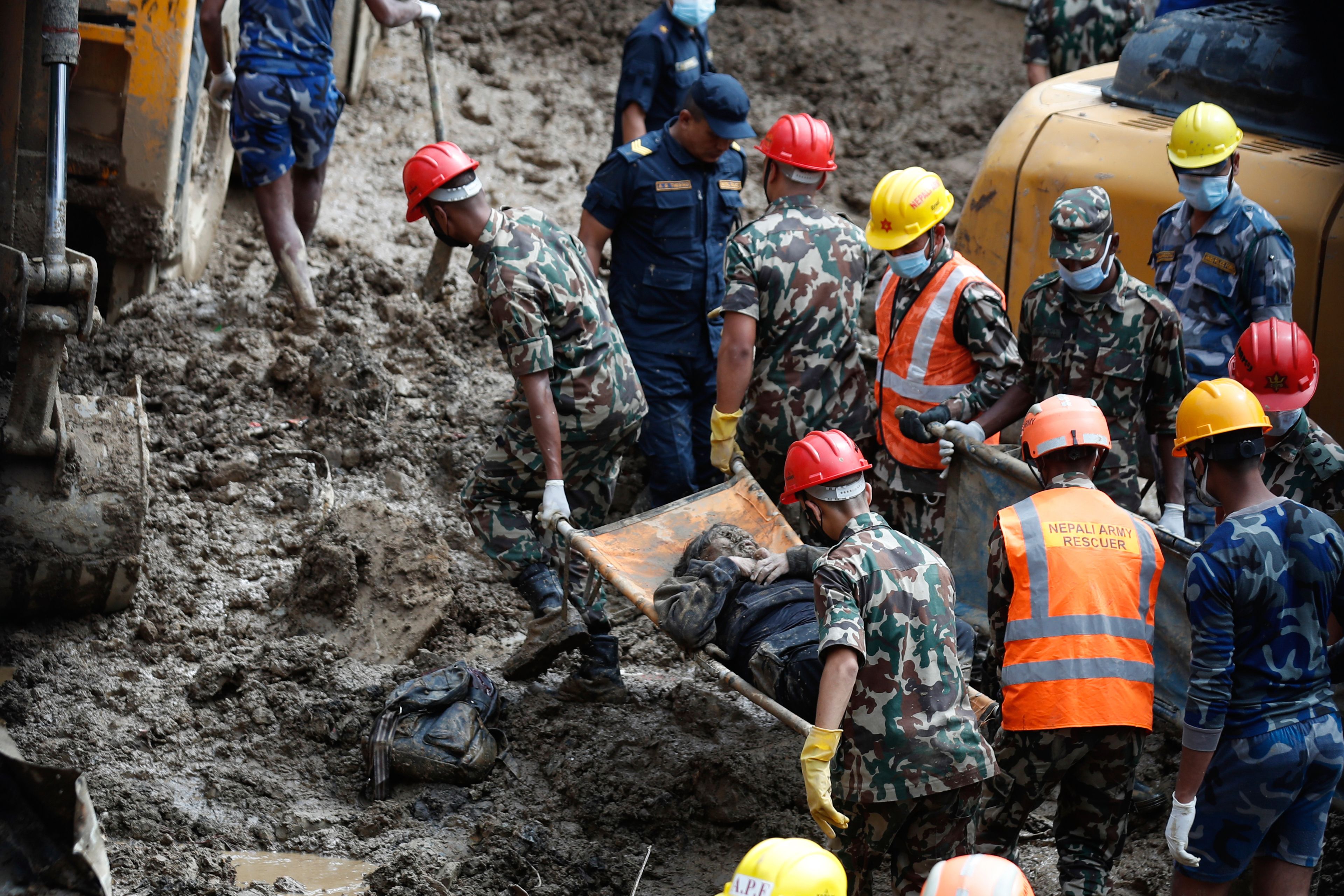 EDS NOTE: GRAPHIC CONTENT - Rescue personnel transport the dead body of a victim who was trapped under a landslide caused by heavy rains in Kathmandu, Nepal, Sunday, Sept. 29, 2024. (AP Photo/Sujan Gurung)