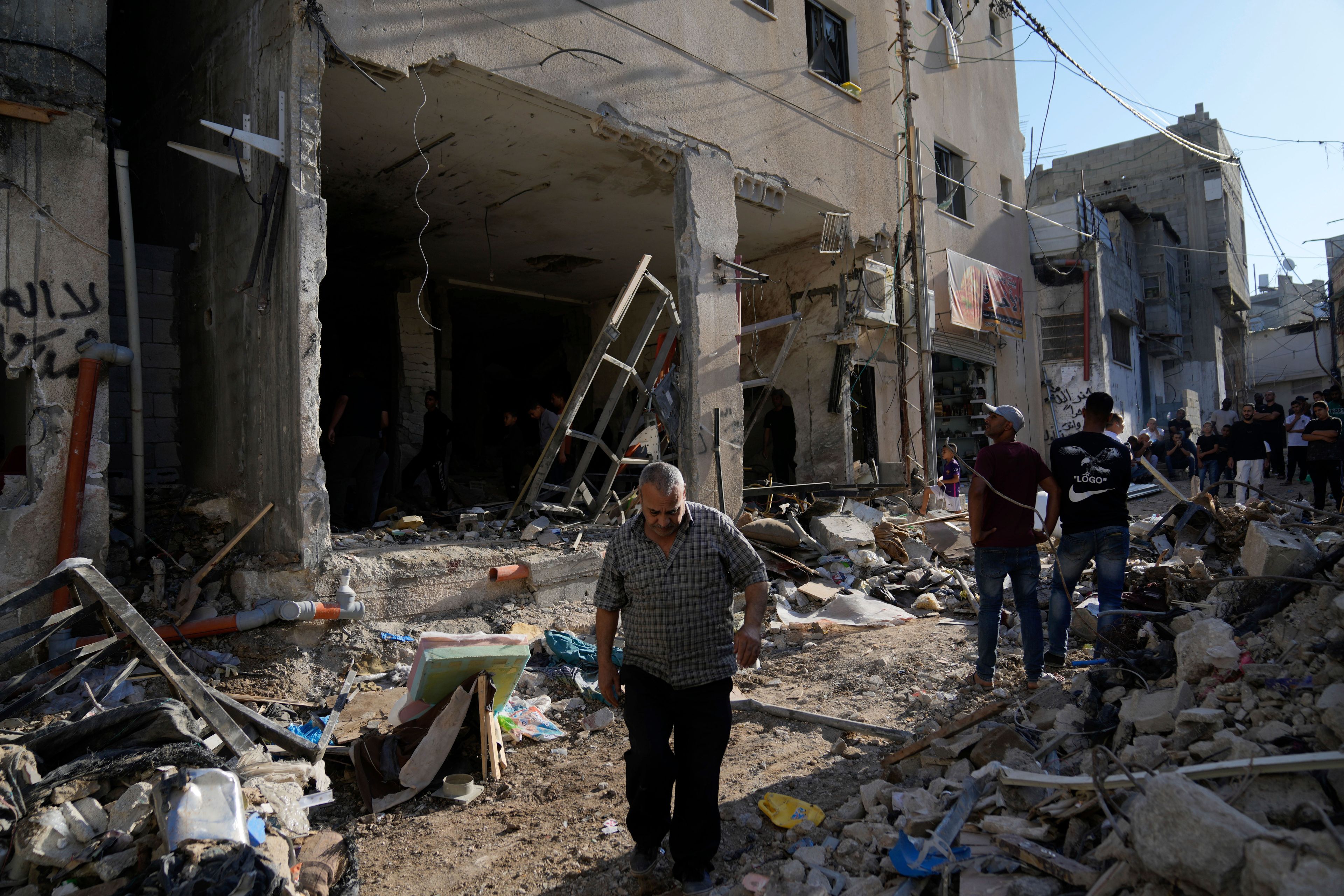 Palestinians examine the damage following an Israeli airstrike in the West Bank city of Tulkarem, which Palestinian health officials say killed 18 people and the Israeli military says took out a Hamas leader, on Friday, Oct. 4, 2024. (AP Photo/Nasser Nasser)