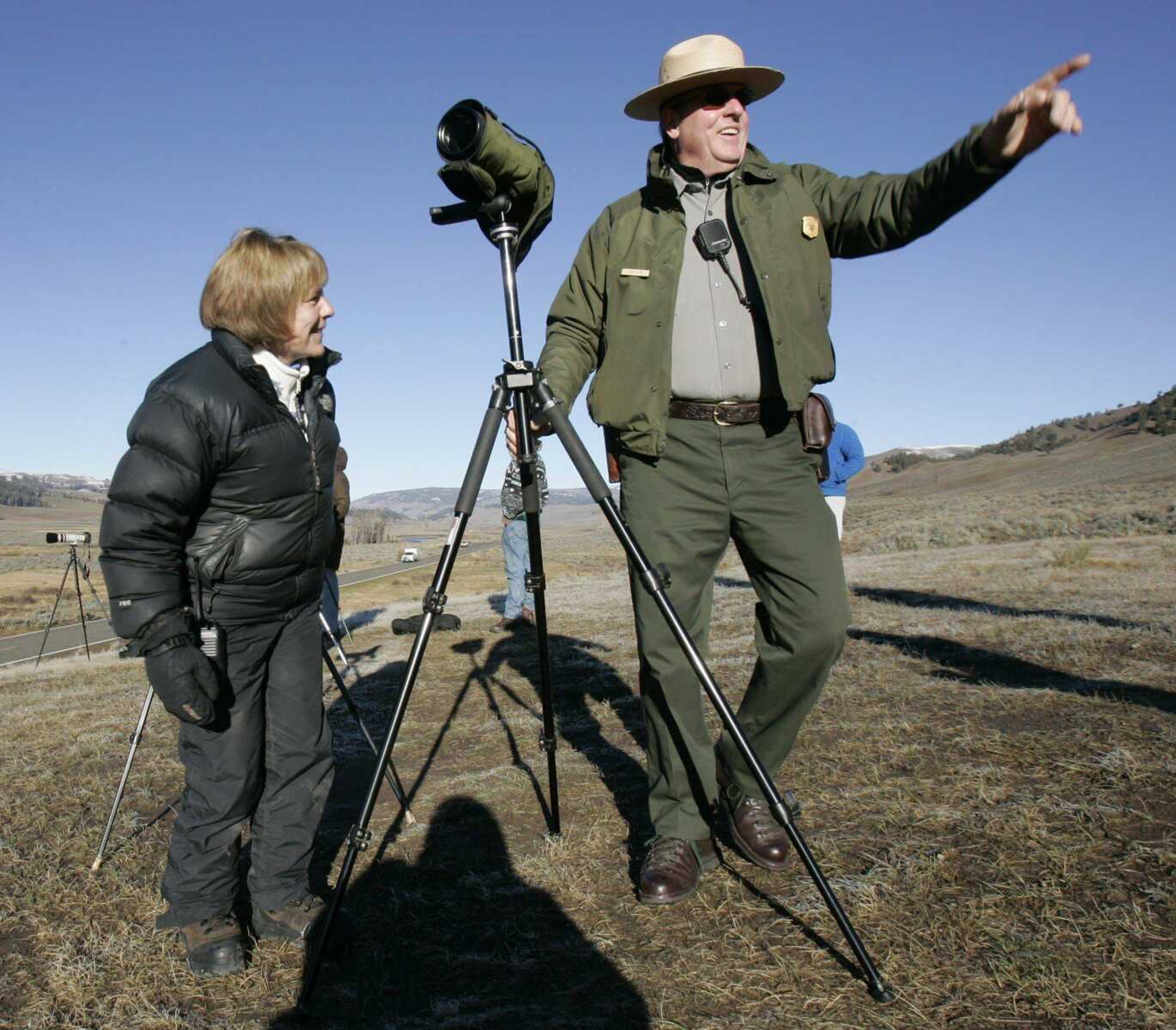 Seasonal ranger John Kerr, right, and Laurie Lyman discussed wolves in Yellowstone National Park, Wyo. Lyman, 55, was an elementary school teacher in San Diego when she began traveling to Yellowstone on long trips to watch wolves. (DOUGLAS C. PIZAC ~ Associated Press)