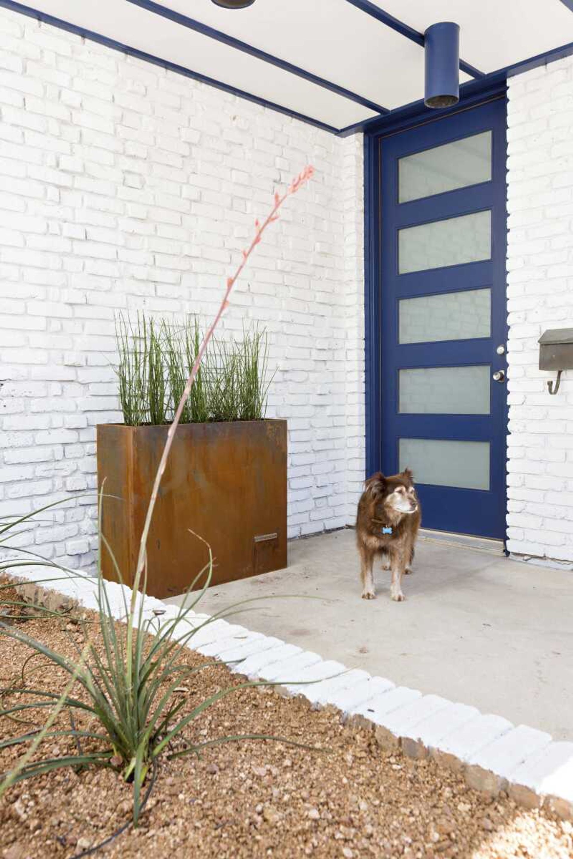 This photo provided by Abbe Fenimore shows a bold blue colored door set against crisp white which creates a cheerful atmosphere in this front entry area designed by Abbe Fenimore, founder of Studio Ten 25 in Dallas, Texas.