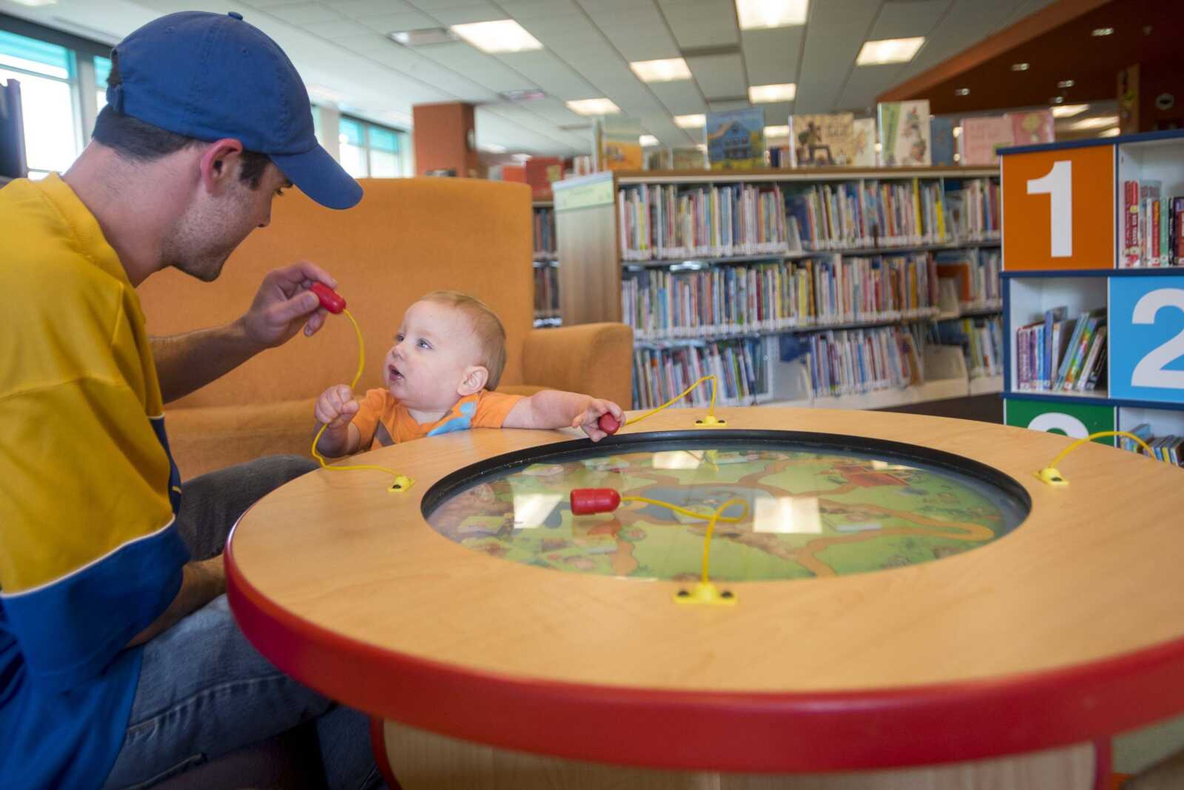 Zack Pullam plays with his 1-year-old son, Logan, on Wednesday at the Cape Girardeau Regional Library.