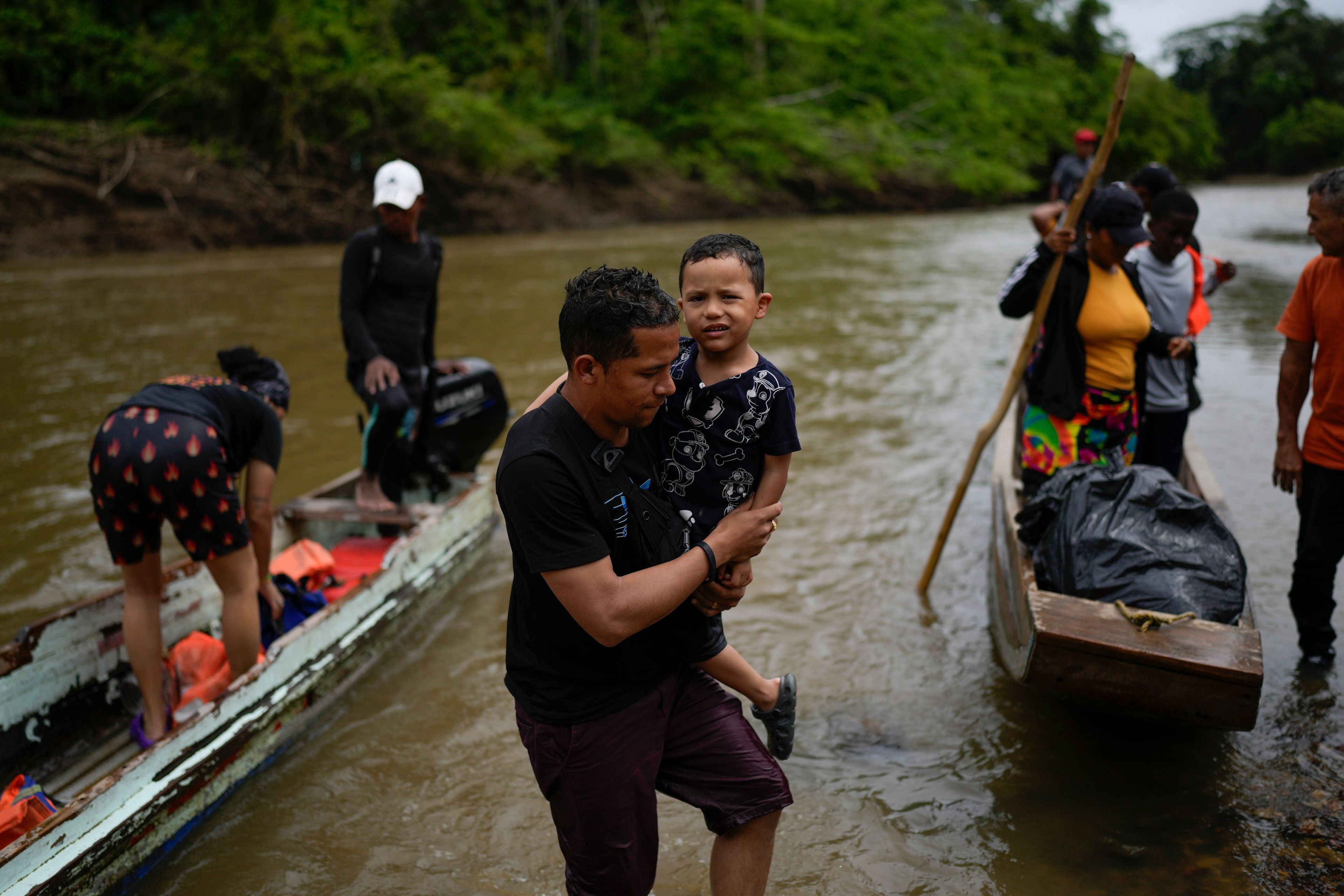 Brayan Quintero and his son Brian, from Venezuela, arrive by boat to Lajas Blancas, Panama, Thursday, Sept. 26, 2024, after walking across the Darien Gap in hopes of reaching the U.S. (AP Photo/Matias Delacroix)