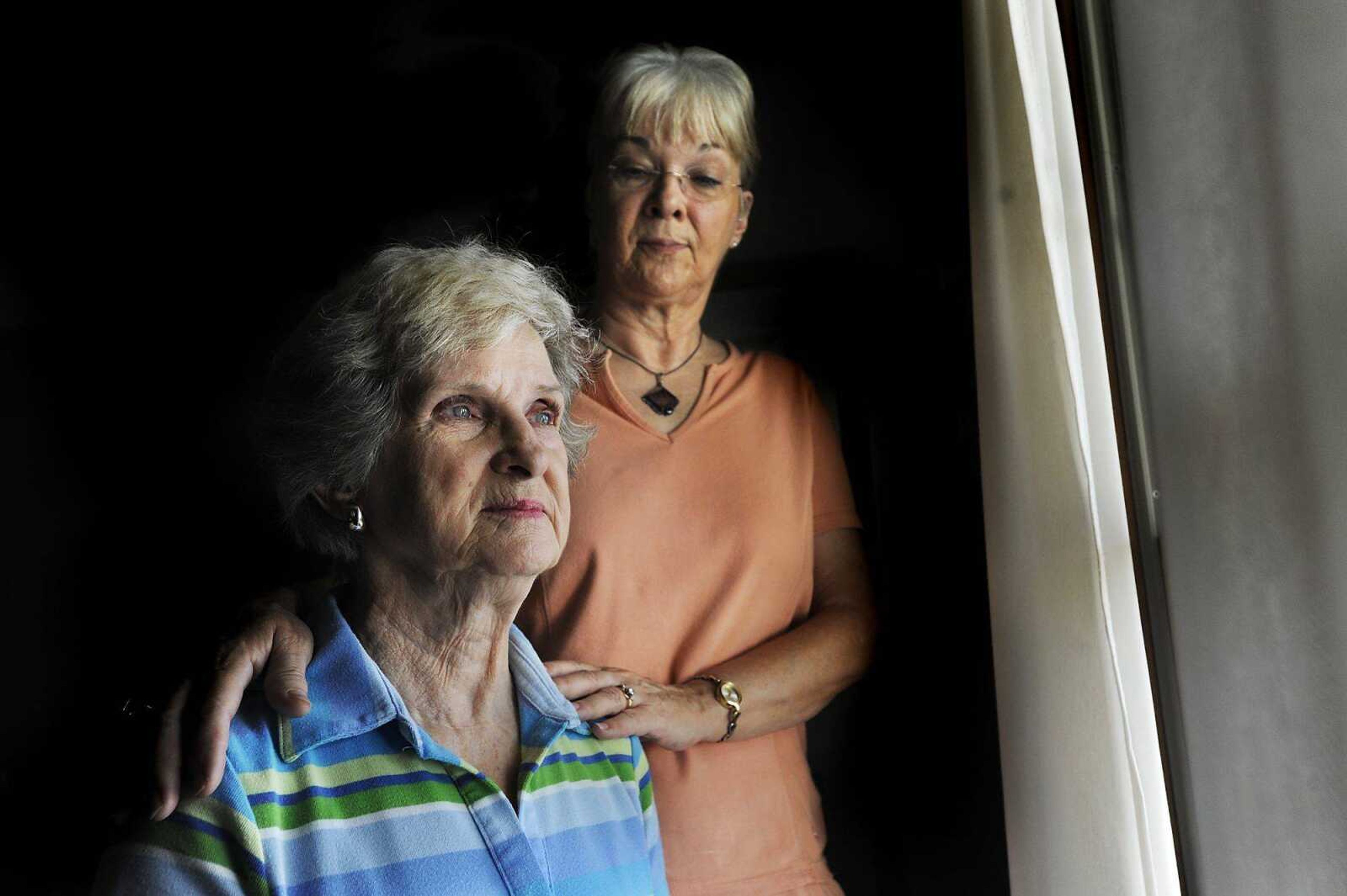 Rhonda Ray, back, and her mother, Lee Fee, look out of the window of their Cape Girardeau home Aug. 14. Fee, who suffers from Alzheimer's, recently moved back to Cape Girardeau from Jefferson City so Ray could help care for her. (ADAM VOGLER)