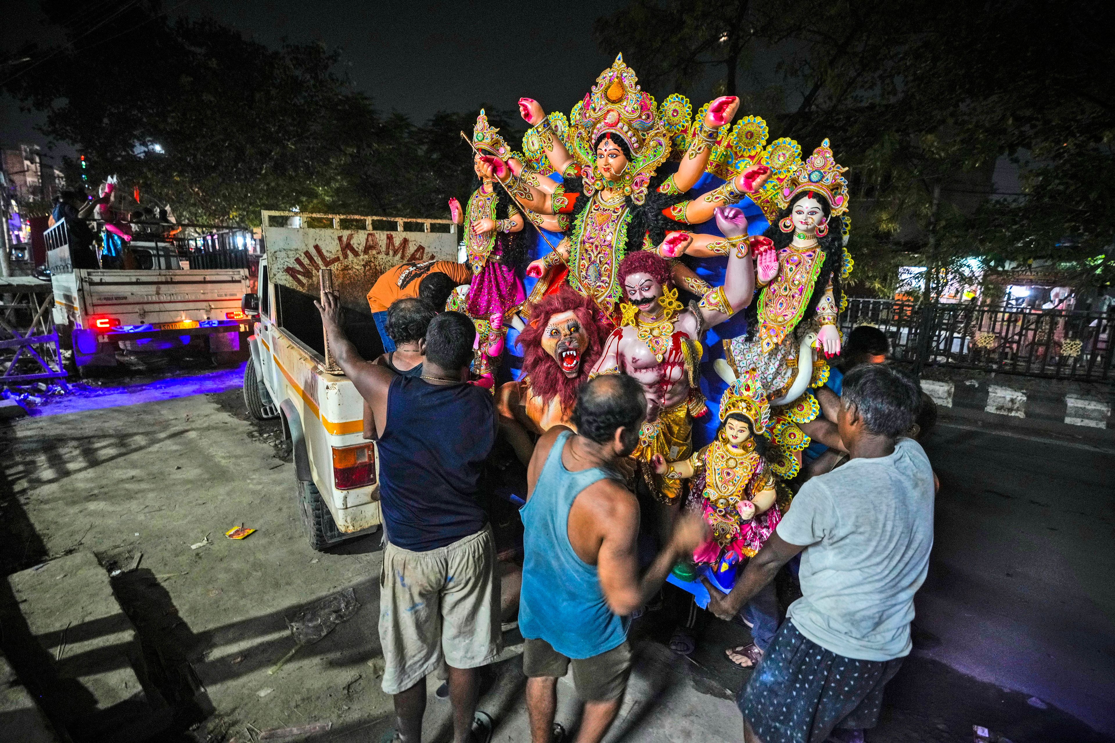 Artisans at a workshop carry a mud idol of the Hindu goddess Durga to load it on to a vehicle during the Durga Puja festival in Guwahati, India, Tuesday, Oct. 8, 2024. (AP Photo/Anupam Nath)