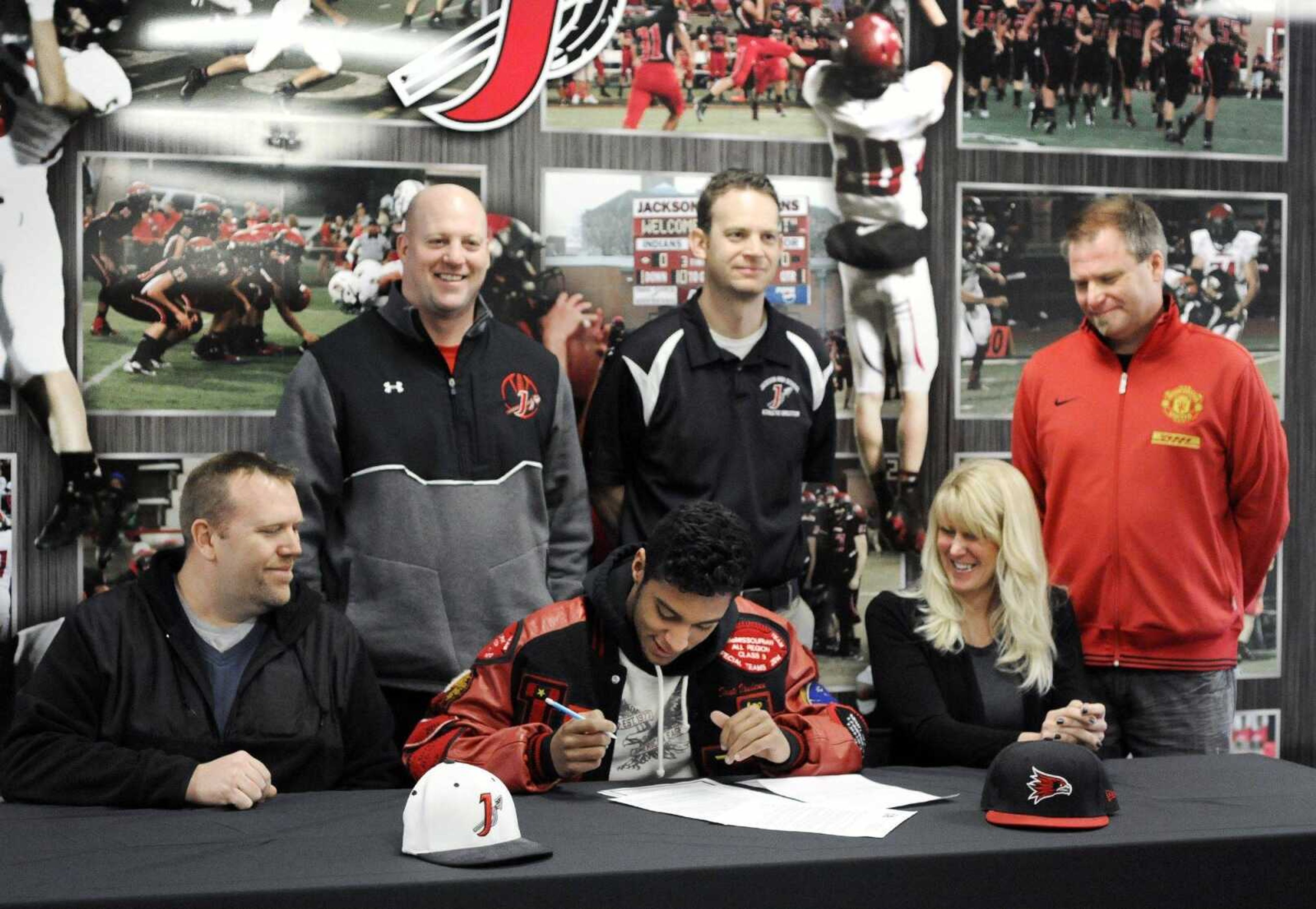 Jackson senior Dante Vandeven signs his letter of intent to play football at Southeast Missouri State University, Wednesday morning, Feb. 4, 2015. Vandeven's parents Bart Vandeven, bottom left, and Jenn Farmer, bottom right, along with Jackson football Brent Eckley, top left, Jackson athletic director John Martin, center, and James Henry attended the morning signing in Jackson. (Laura Simon)