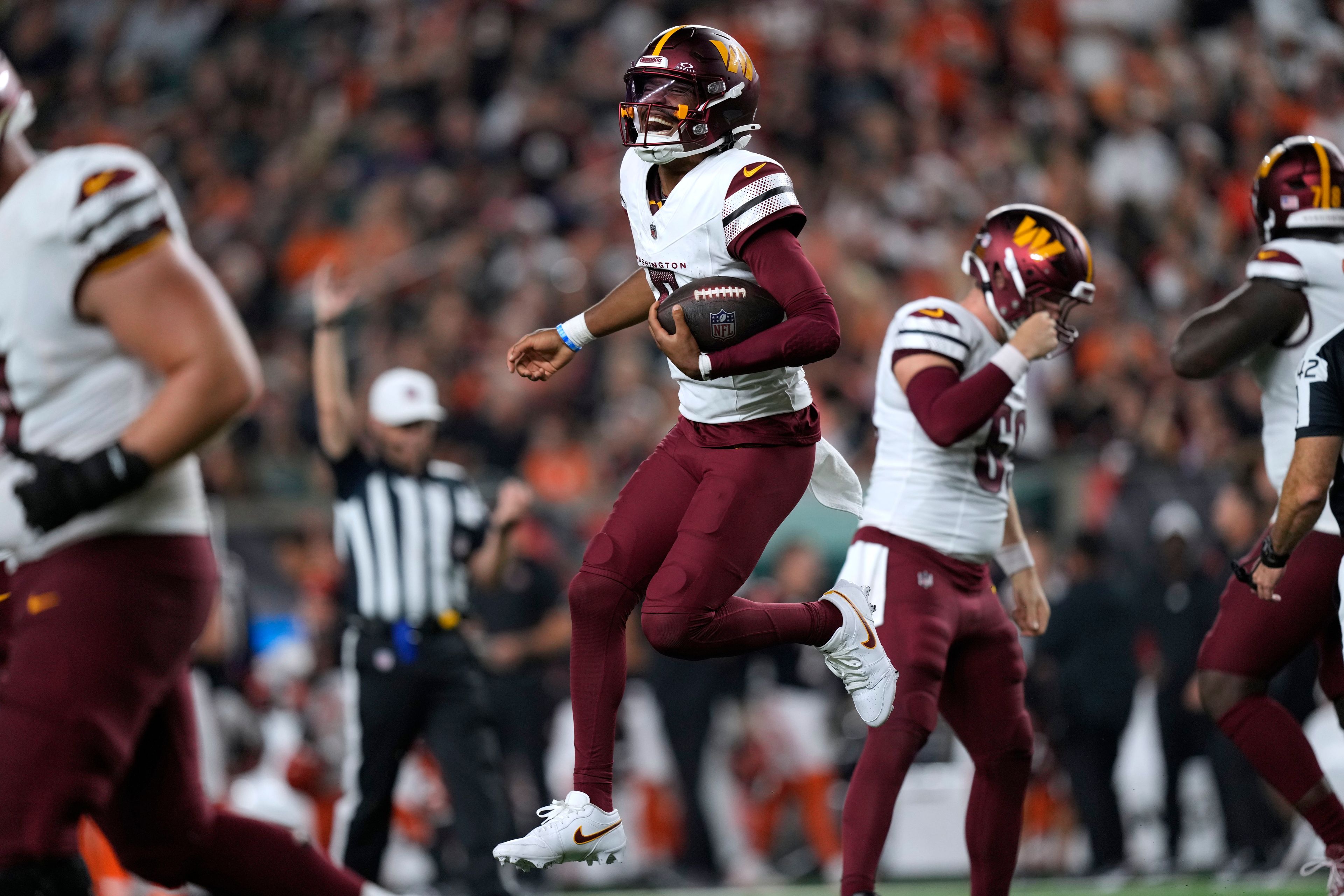 Washington Commanders quarterback Jayden Daniels celebrates after throwing a touchdown pass during the second half of an NFL football game against the Cincinnati Bengals, Monday, Sept. 23, 2024, in Cincinnati. (AP Photo/Carolyn Kaster)