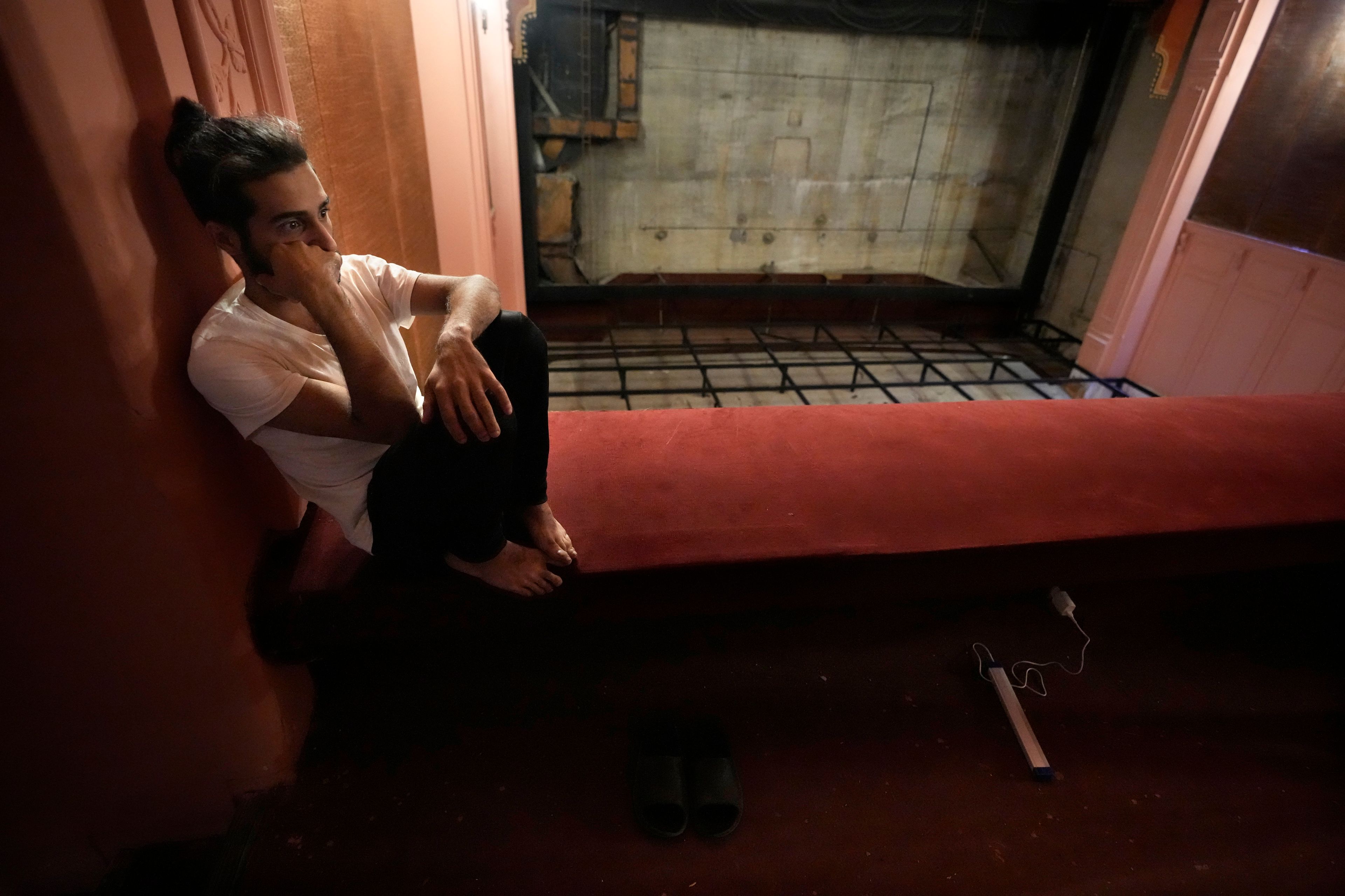 Ahmad Mansour, who fled the ongoing Hezbollah-Israel war in south Lebanon, sits inside one of Beirut's oldest and best known movie theatres, Le Colisee, where he has taken shelter with his family, in Beirut, Lebanon, Tuesday, Oct. 22, 2024. (AP Photo/Hussein Malla)