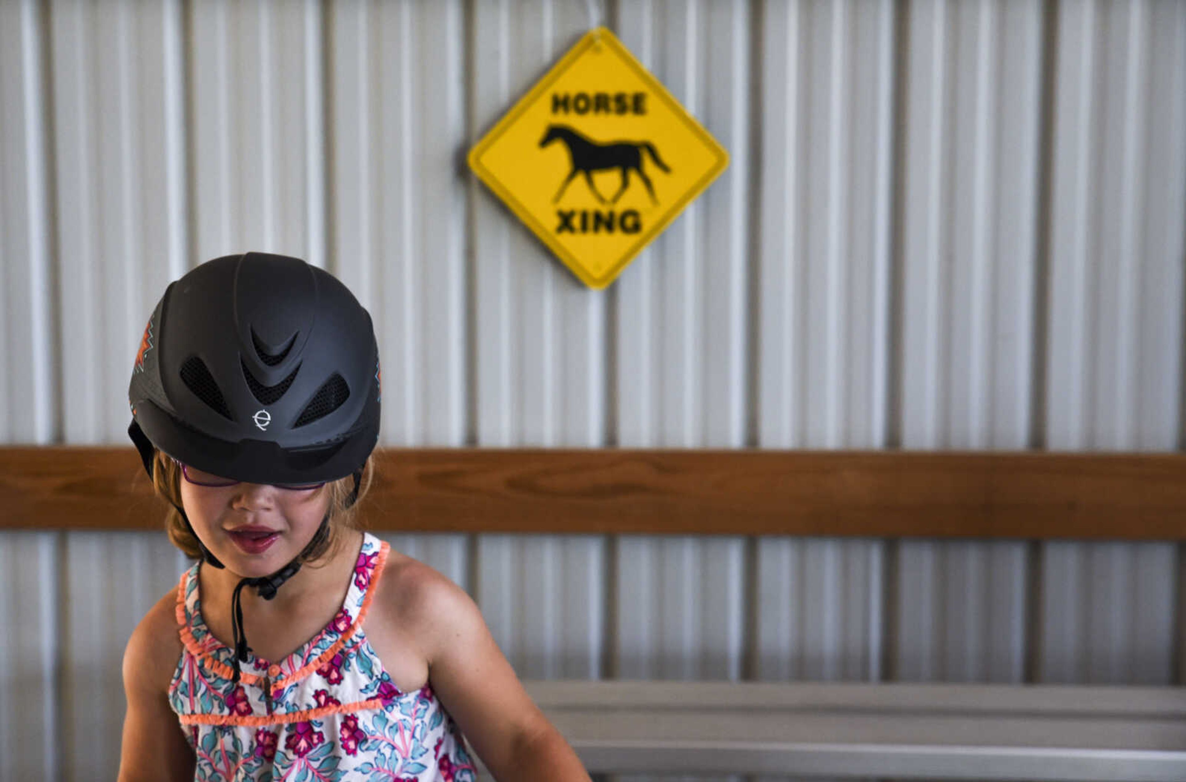 Lindyn Davenport, 6, stands up to jump down off of risers during a summer camp session at Mississippi Valley Therapeutic Horsemanship Friday, June 8, 2018 in Oak Ridge.