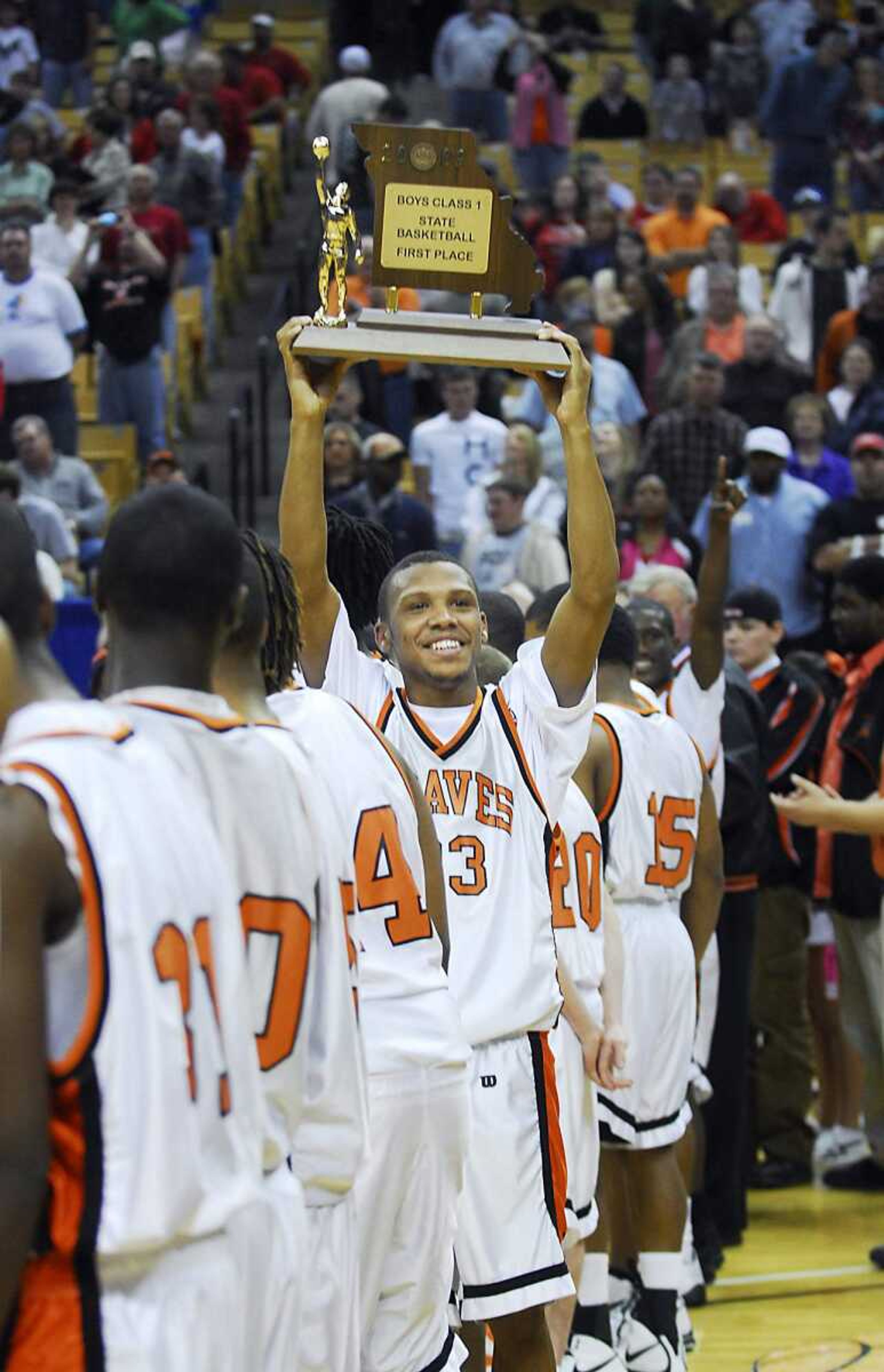 KIT DOYLE ~ kdoyle@semissourian.com
Scott County Central senior Drew Thomas holds up the Class 1 state championship trophy toward the fan section Saturday, March 21, 2009, at Mizzou Arena in Columbia.