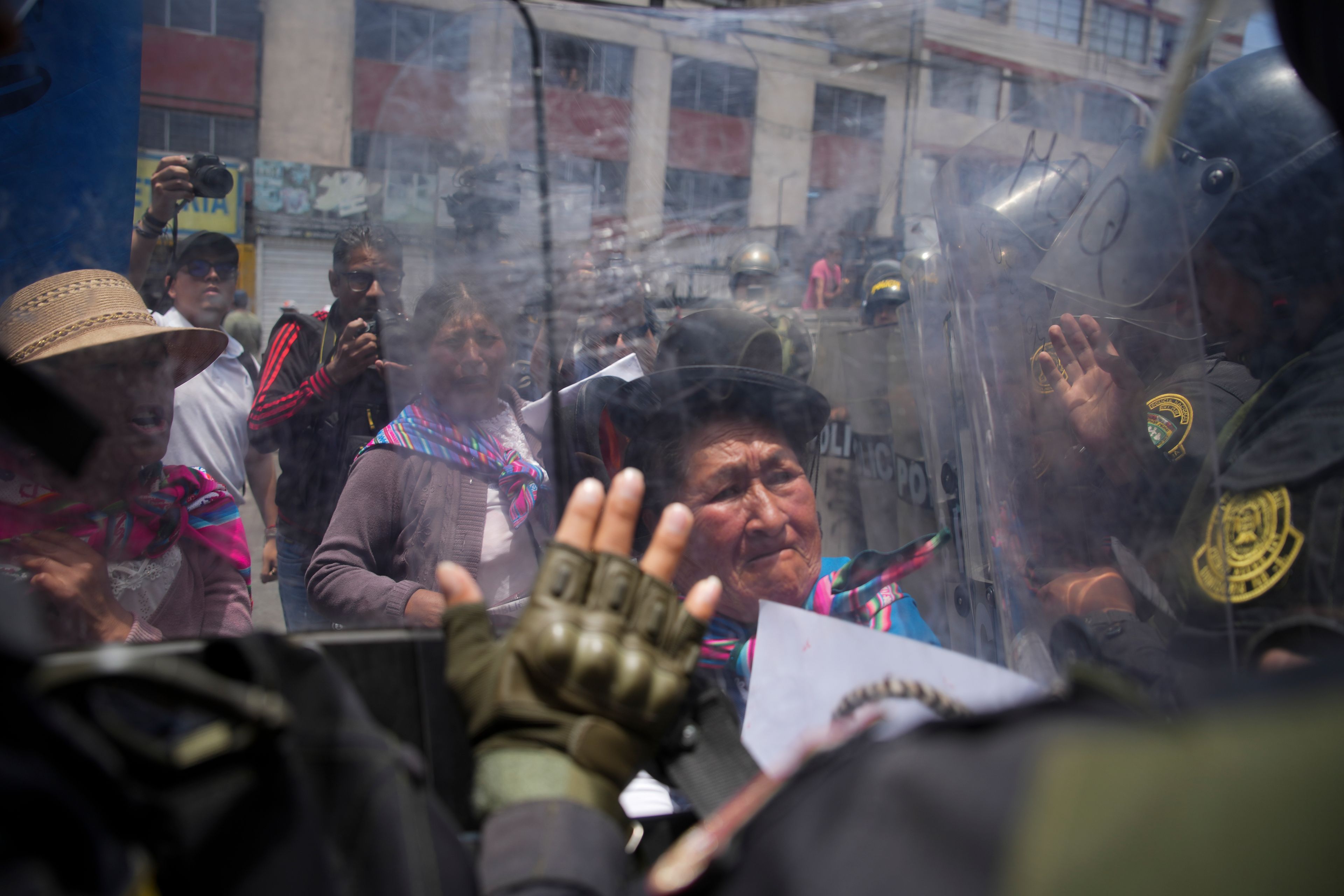 An anti-government protester confronts a cordon of police officers during a demonstration on the sidelines of the Asia-Pacific Economic Cooperation (APEC) summit in Lima, Peru, Nov. 15, 2024. (AP Photo/Guadalupe Pardo)