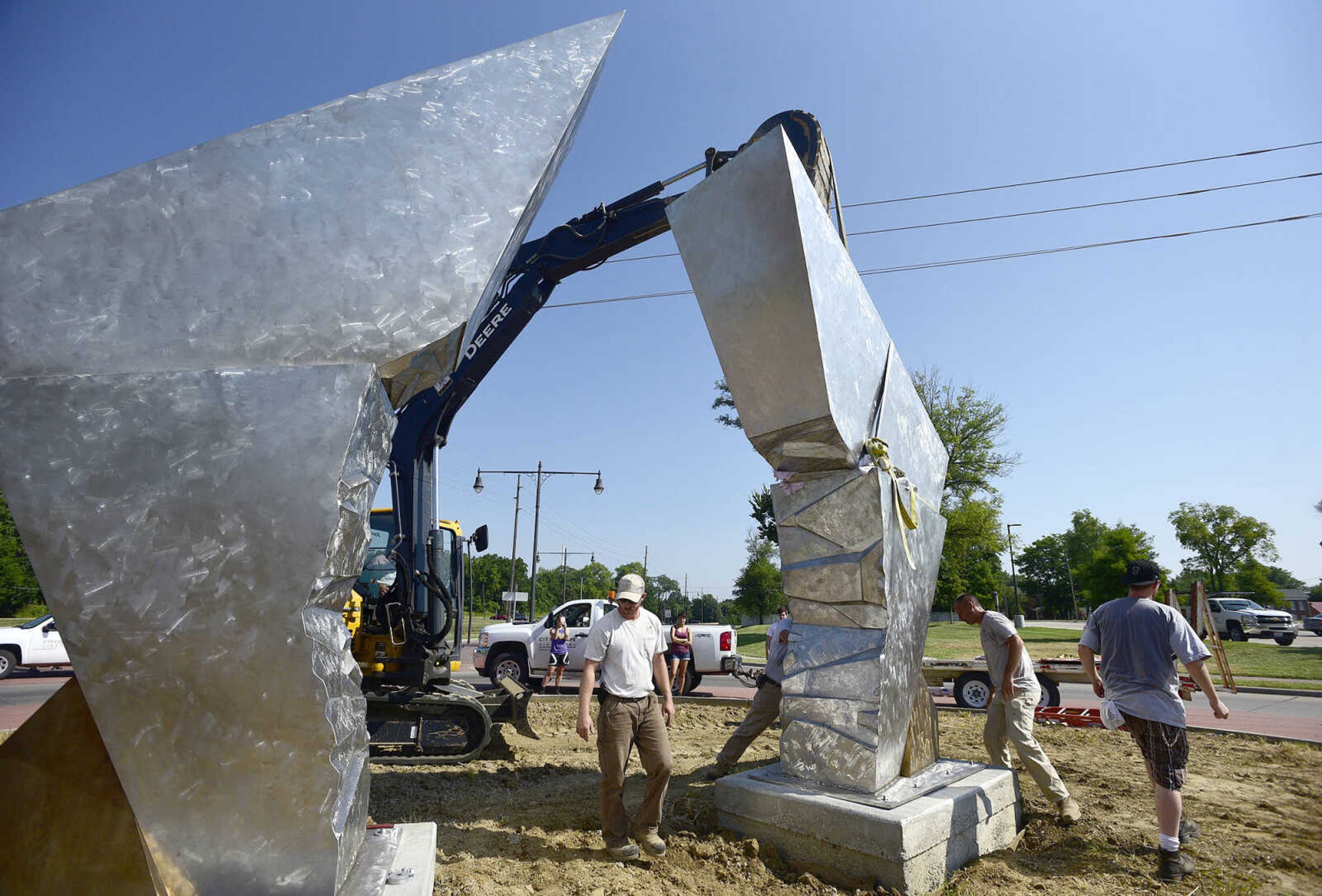 Cape Girardeau Parks and Recreation employees install the second piece of Chris Wubbena's 14-foot sculpture, "Commence", in the Fountain Street roundabout on Monday, July 24, 2017, near the River Campus in Cape Girardeau.