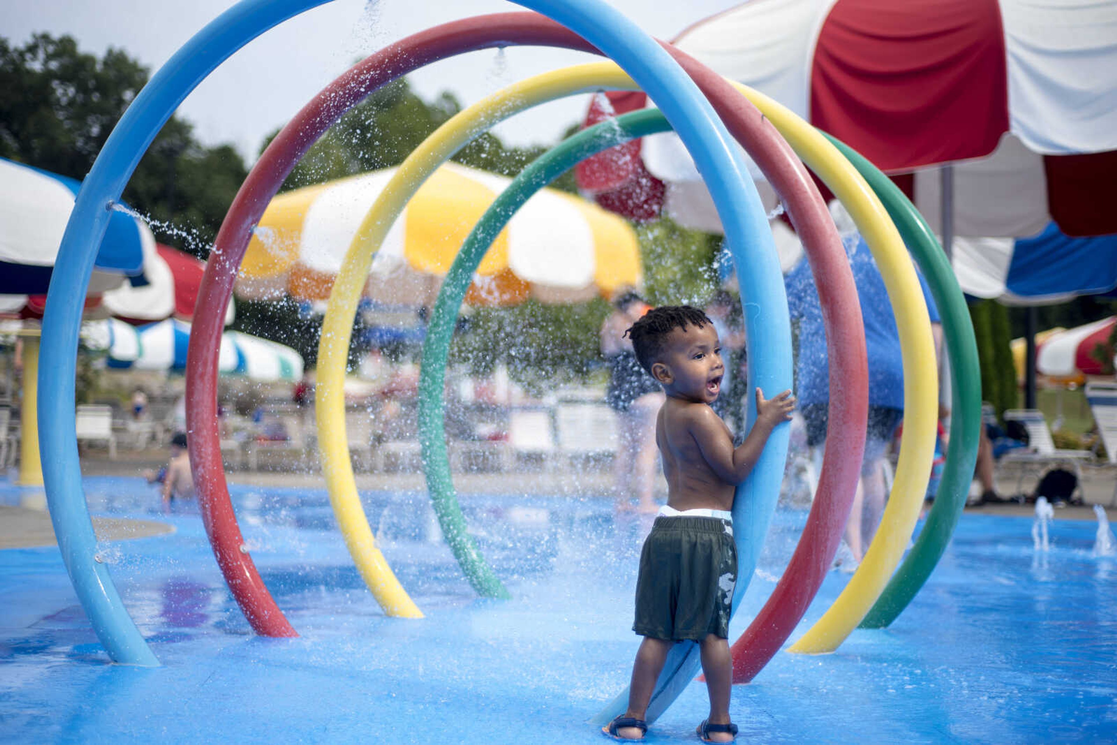 Tyson Mack, 2, hugs a ring-shaped sprinkler at the Splash Pad on Sunday, Aug. 11, 2019, at Cape Splash in Cape Girardeau.