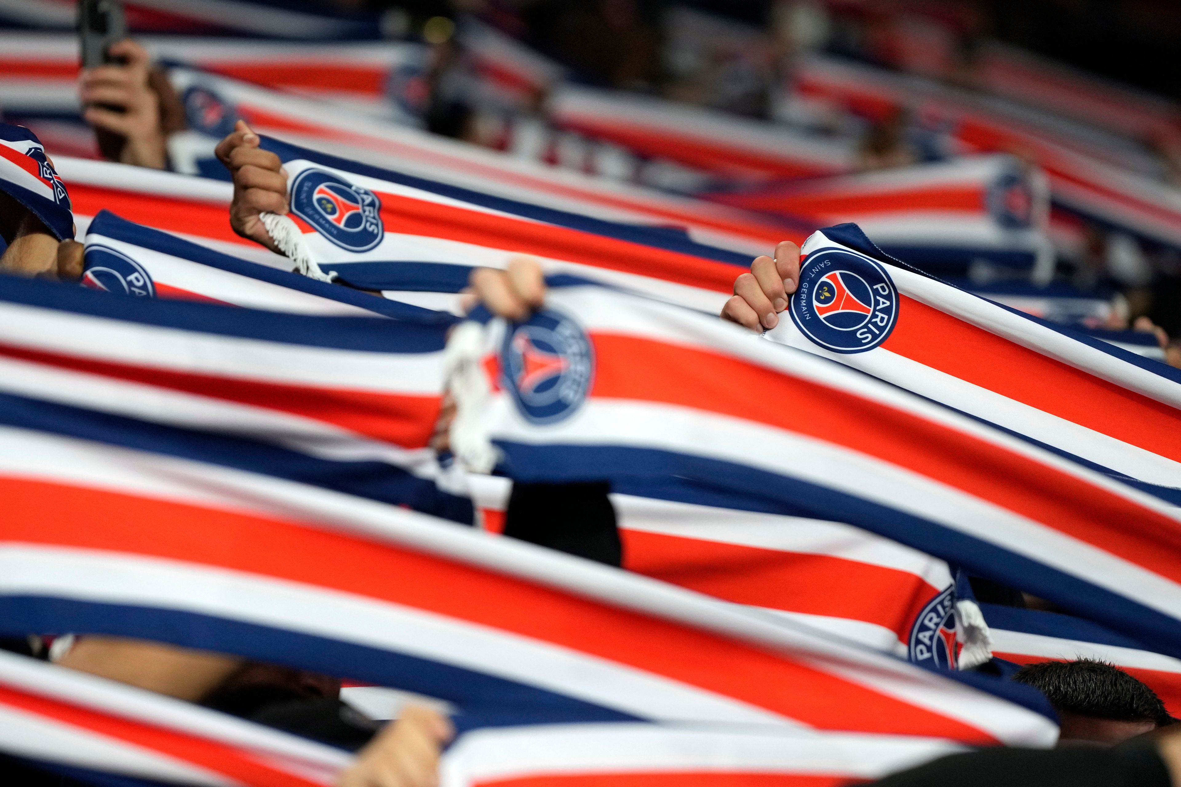 PSG fans hold up their scarves on the stands before the start of a Champions League opening phase soccer match between Arsenal FC and Paris Saint-Germain at Arsenal stadium in London, England, Tuesday, Oct. 1, 2024. (AP Photo/Alastair Grant)