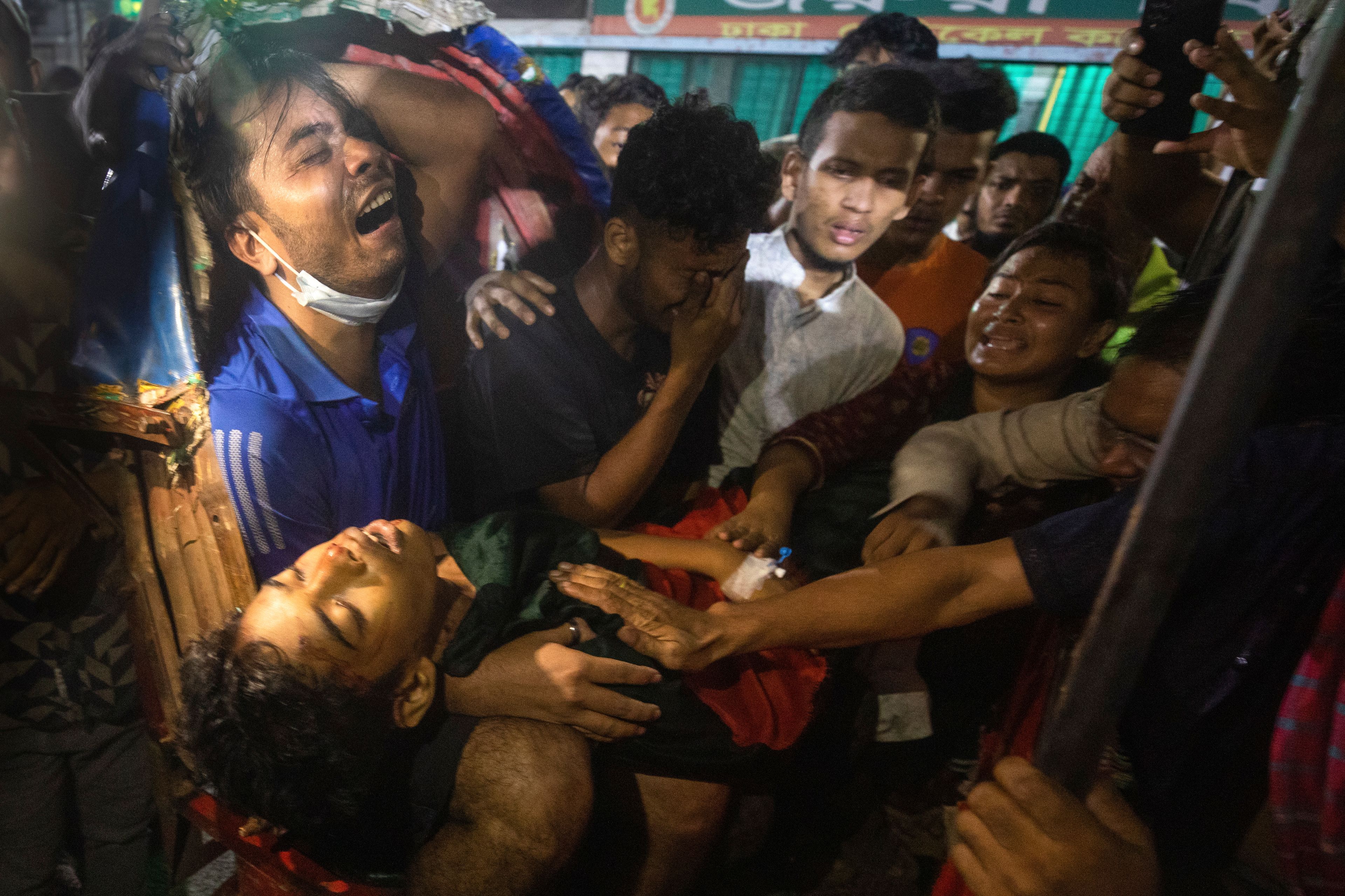 People cry as the body of a man who was killed during anti-government protests in Bangladesh is brought to a hospital in Dhaka, on Aug. 4, 2024. (AP Photo/Rajib Dhar)