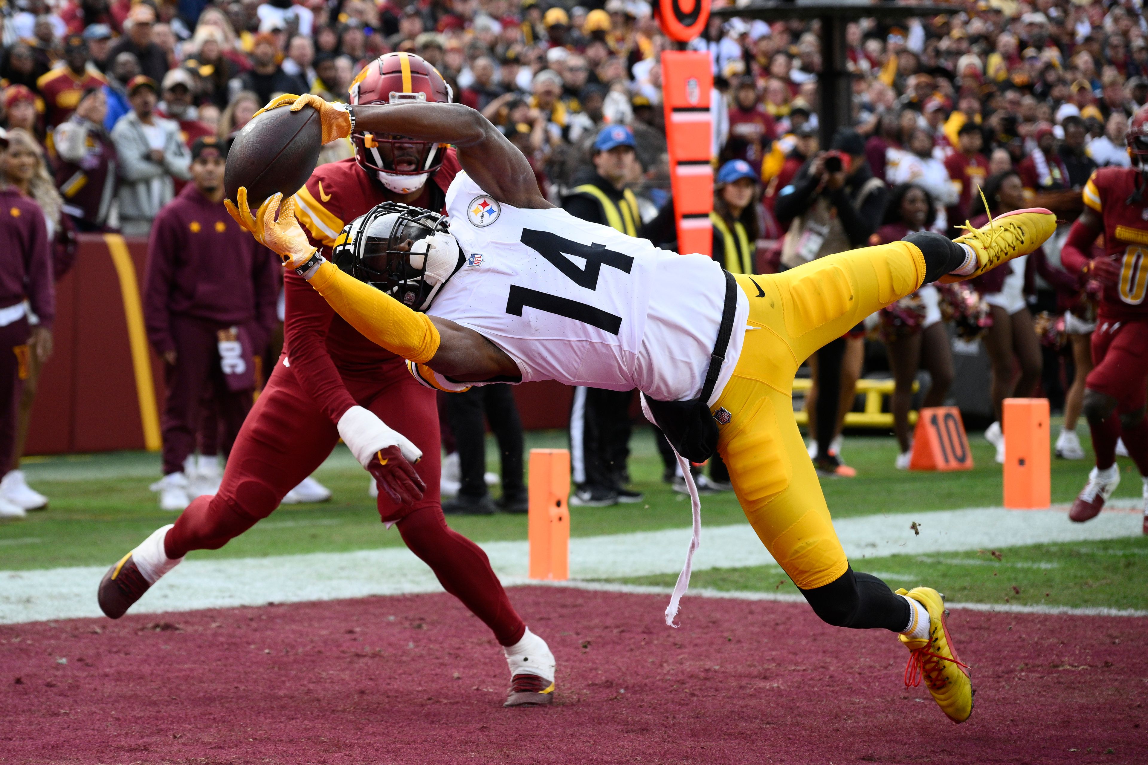 Pittsburgh Steelers wide receiver George Pickens (14), defended by Washington Commanders cornerback Noah Igbinoghene, catches a 16-yard pass for a touchdown during the first half of an NFL football game, Sunday, Nov. 10, 2024, in Landover, Md. (AP Photo/Nick Wass)