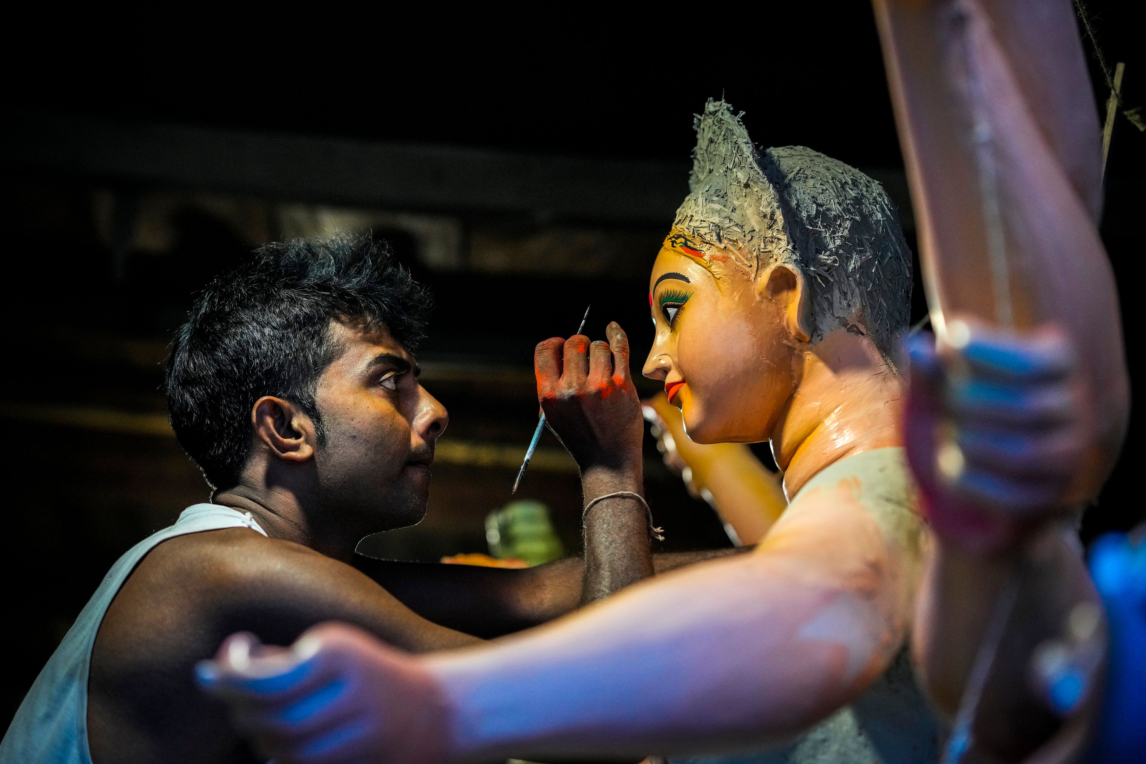 Kanchan Paul, 39, paints the eyes on an idol of the Hindu goddess Durga at his workshop during the Durga Puja festival in Guwahati, India, Friday, Oct. 4, 2024. (AP Photo/Anupam Nath)