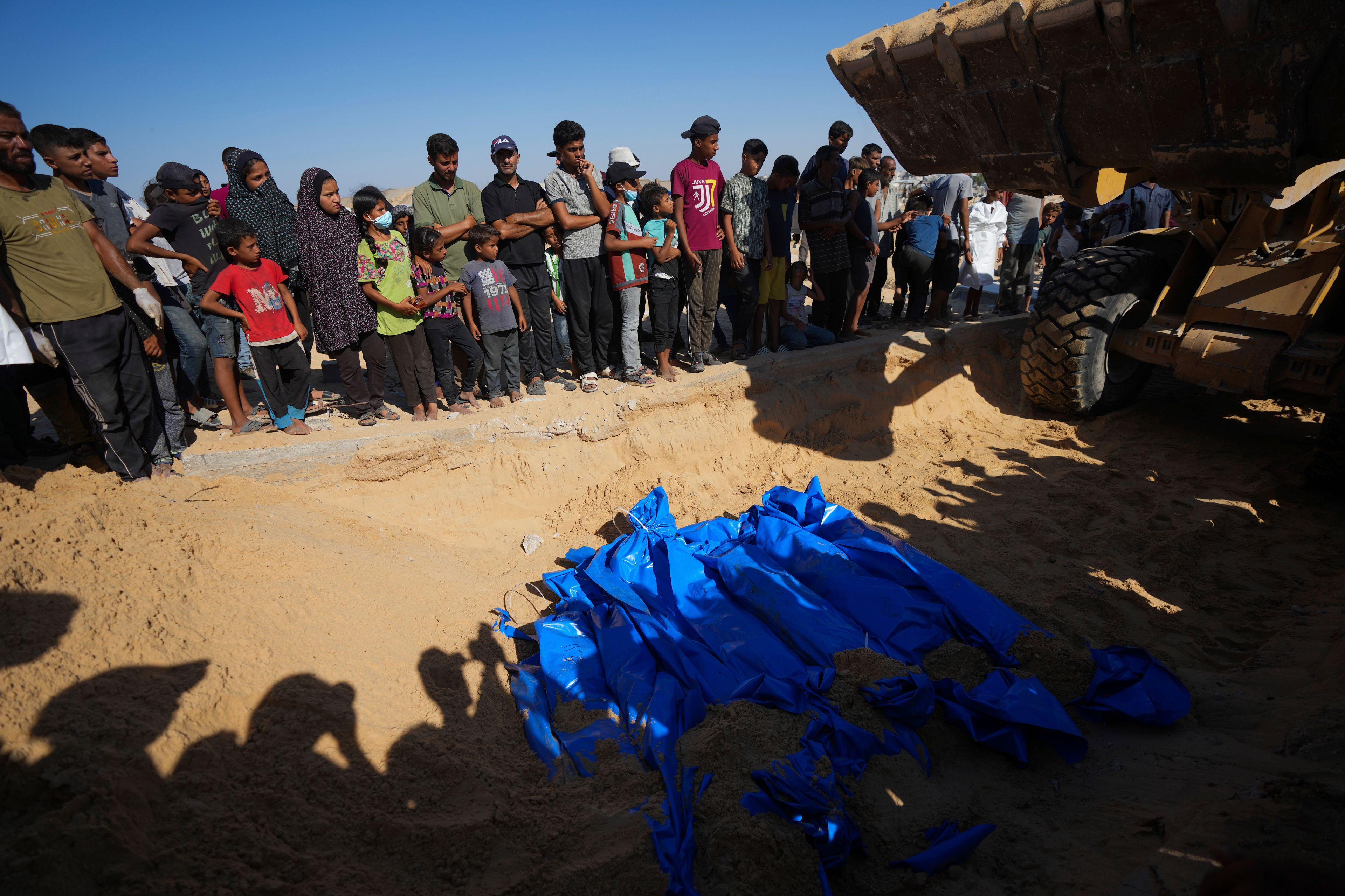 People bury the bodies of Palestinians taken by the Israeli military during operations in Gaza and returned this week, in Khan Younis, Gaza Strip, Thursday, Sept. 26, 2024. (AP Photo/Abdel Kareem Hana)