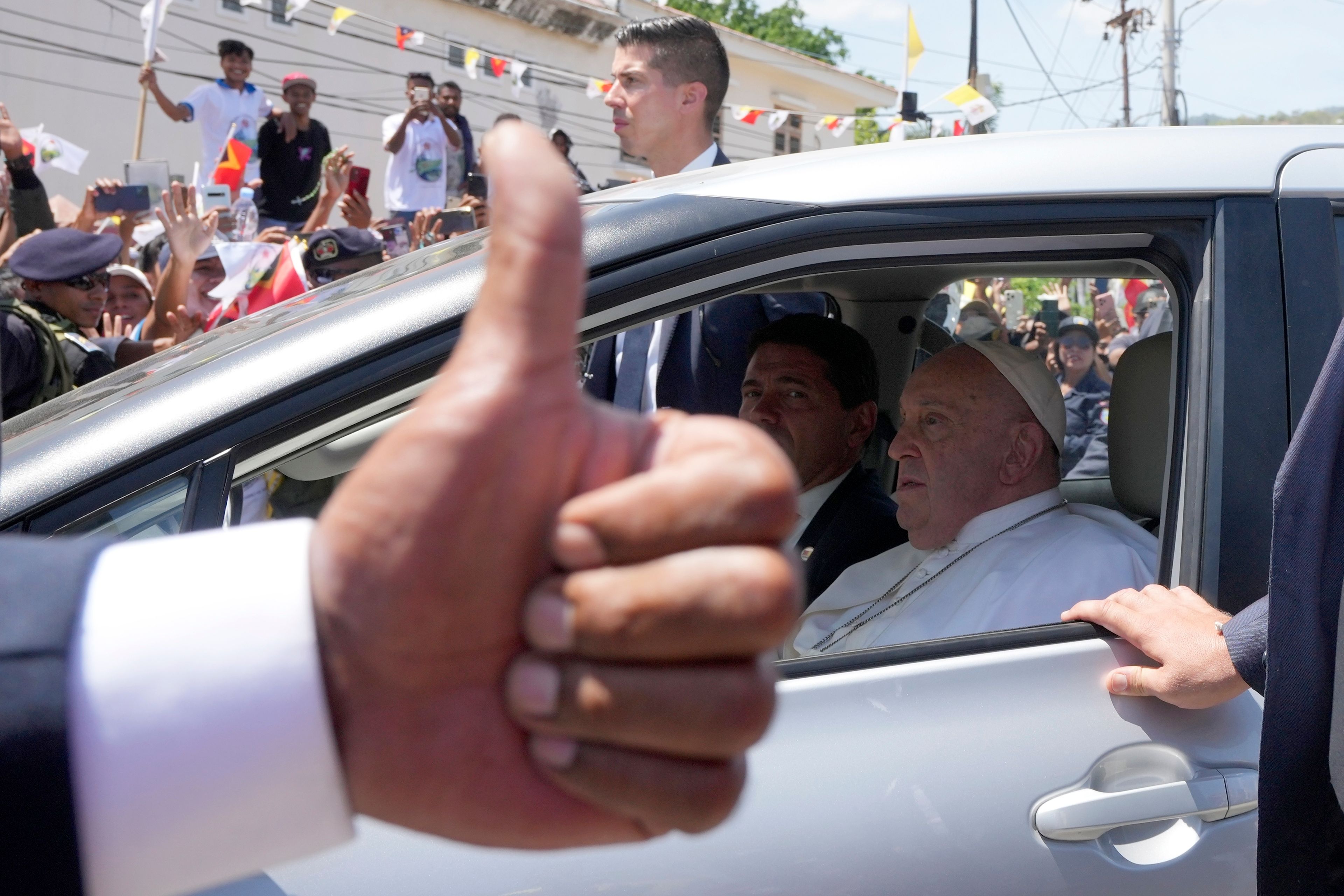 People greet Pope Francis as he travels in a car on way to another venue in Dili, East Timor, Tuesday, Sept. 10, 2024. (AP Photo/Firdia Lisnawati)