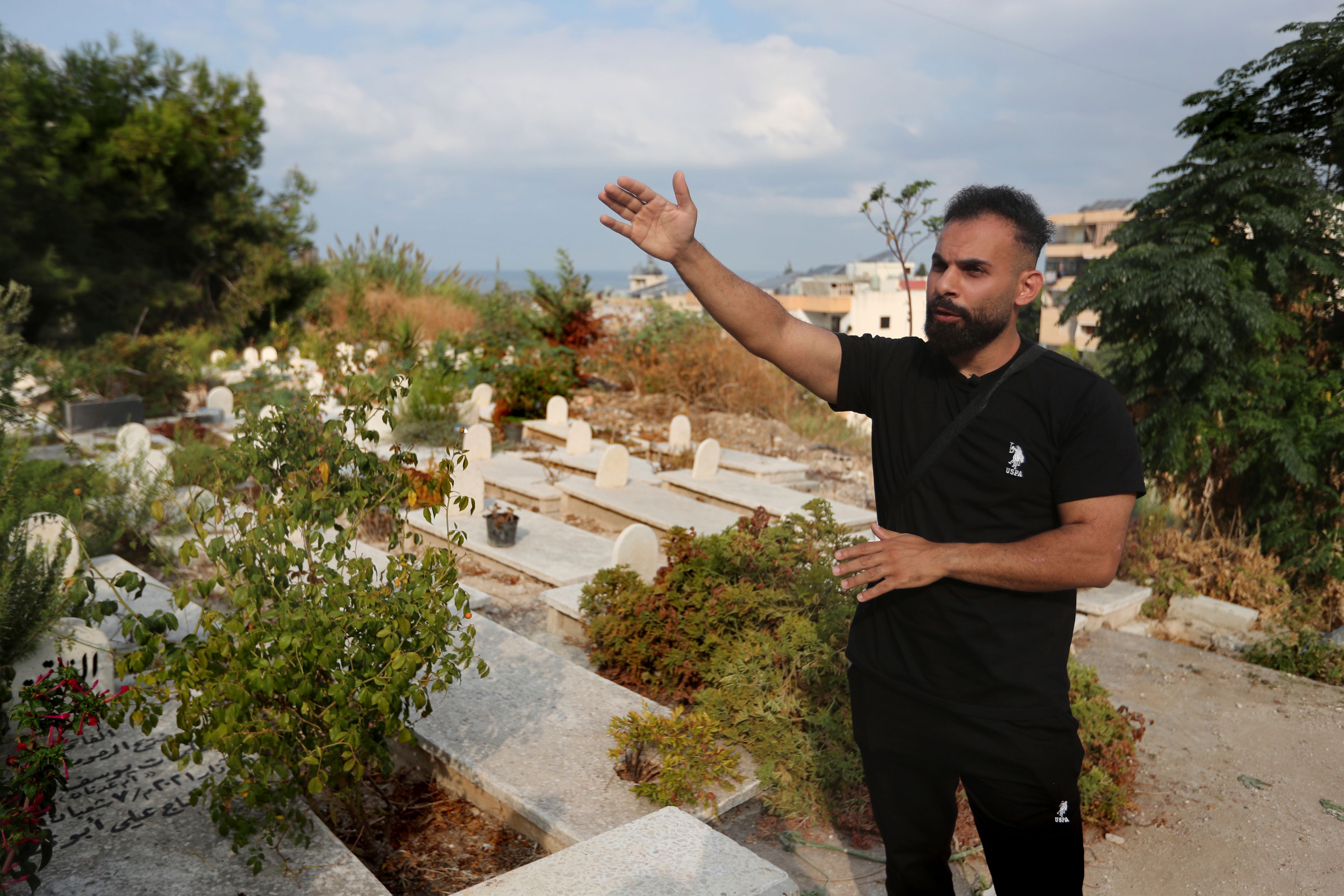 Achraf Ramadan gestures while visiting the cemetery where his mother and his sister who were killed on Sept. 29 in the deadliest Israeli strike in the first week of escalation between Israel and Hezbollah, in the southern port city of Sidon, Lebanon, Thursday, Oct. 10, 2024. (AP Photo/Mohammed Zaatari)