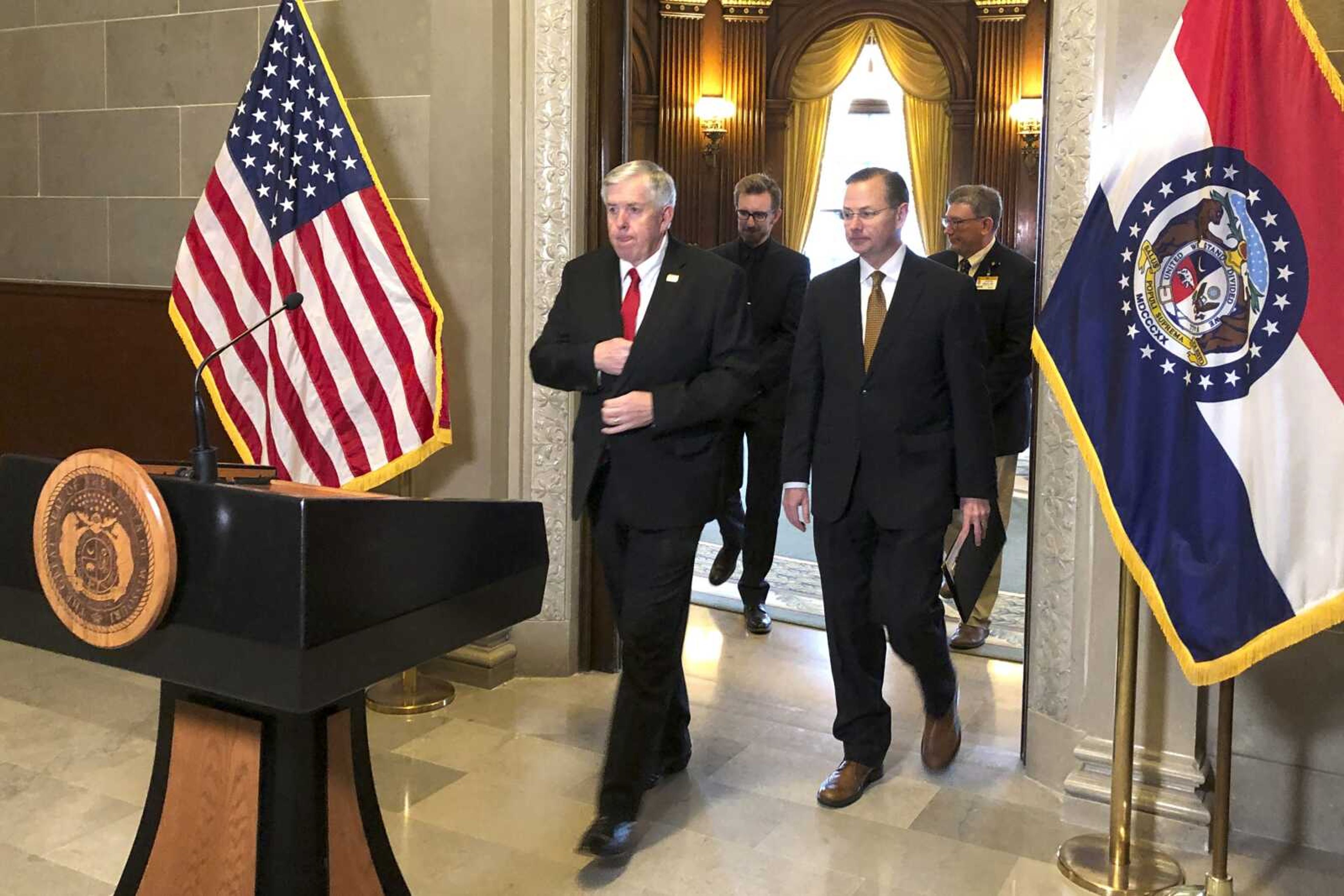 Gov. Mike Parson, left, and Columbia Mayor Brian Treece emerge from the governor's office Wednesdasy in the state Capitol in Jefferson City, Missouri. Parson announced Missouri's first death from the virus that causes the COVID-19 disease occurred Wednesday. Treece said it happened at University Hospital in Columbia.