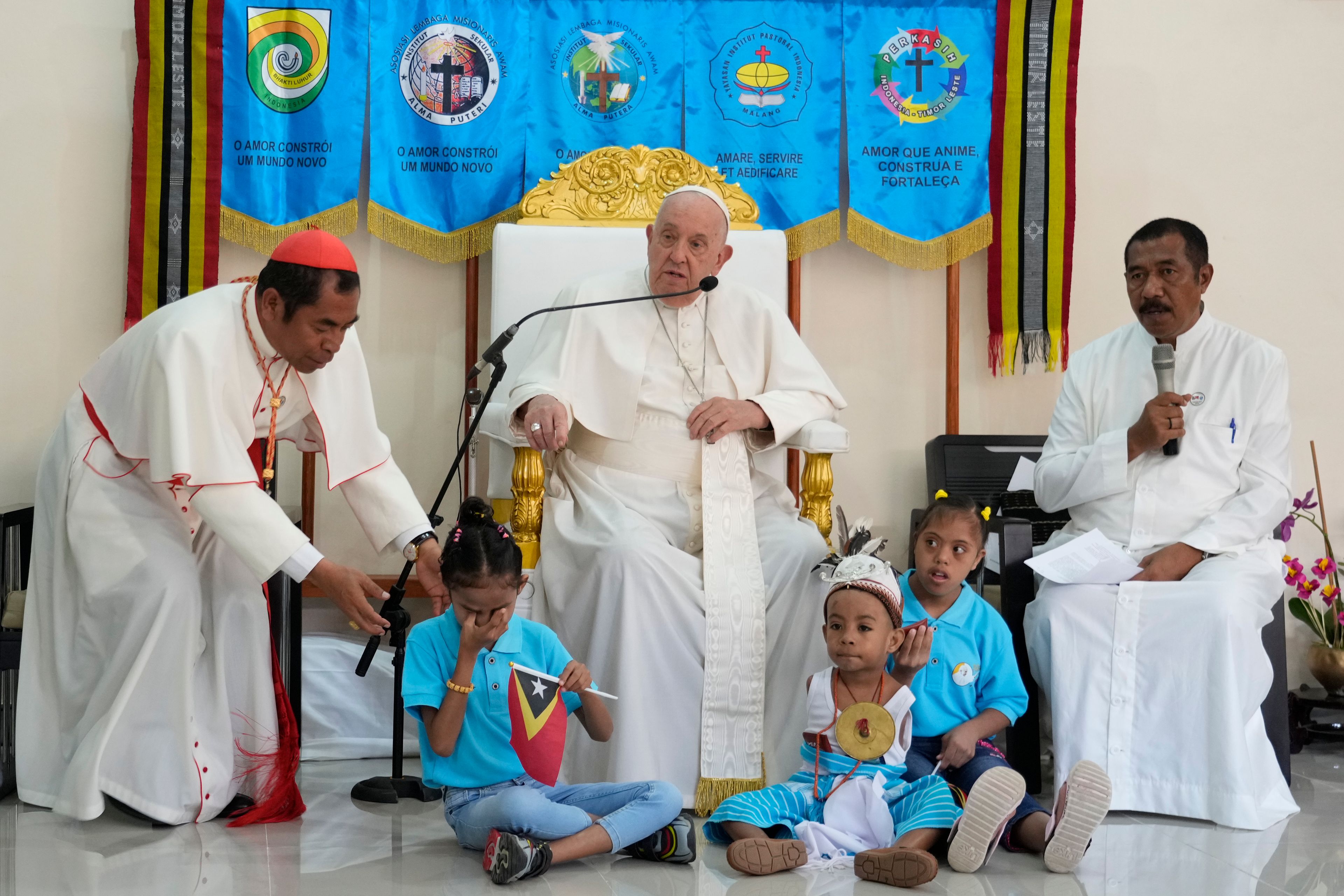 Pope Francis speaks during a visit at the 'Irmas ALMA' (Sisters of the Association of Lay Missionaries) School for Children with Disabilities in Dili, East Timor, Tuesday, Sept. 10, 2024. Pope Francis has indirectly acknowledged the abuse scandal in East Timor involving its Nobel Peace Prize-winning independence hero Bishop Carlos Filipe Ximenes Belo. At left is Archbishop of Dili Cardinal Virgilio do Carmo da Silva. (AP Photo/Gregorio Borgia)