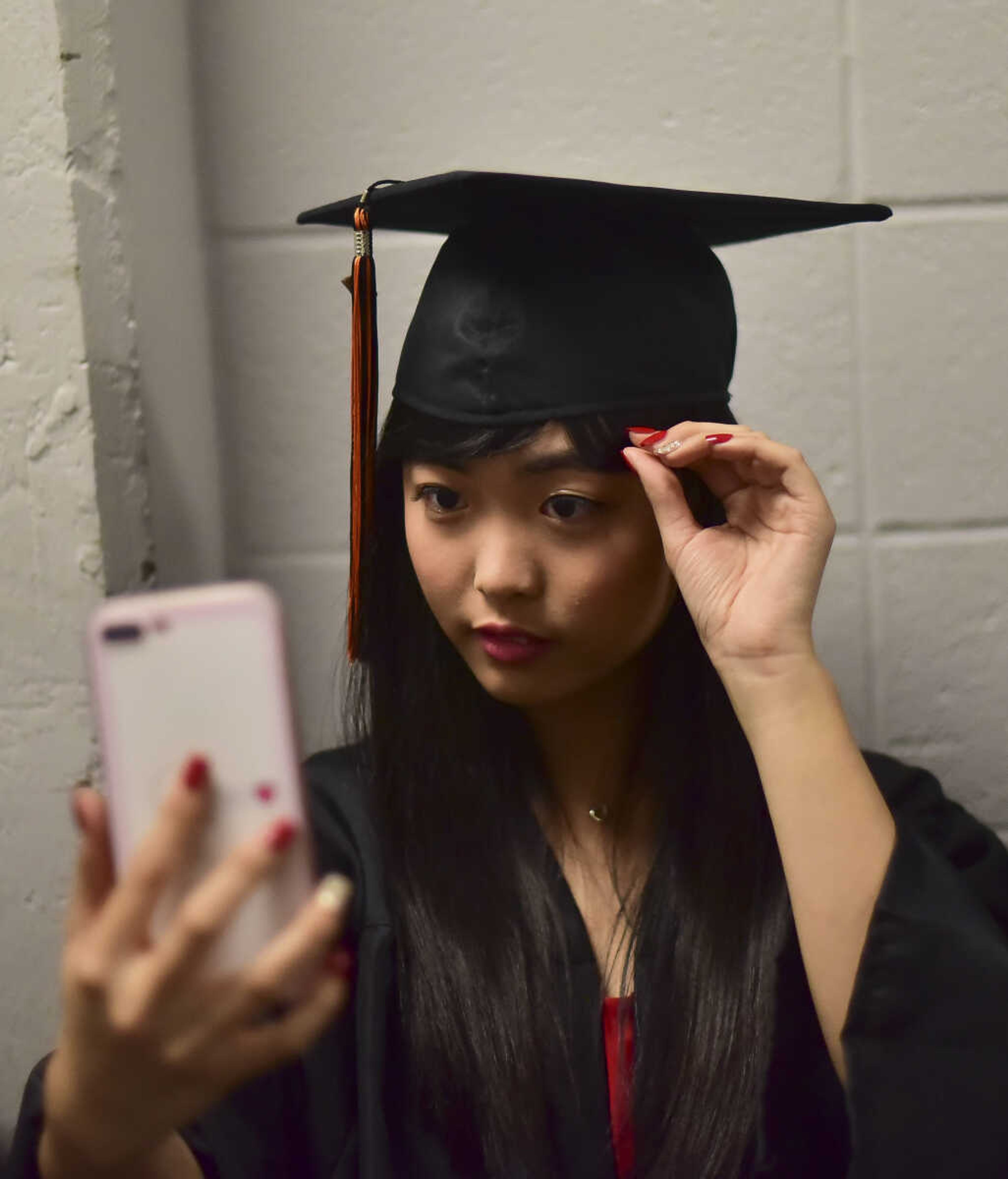 Tracy Cai takes a photo during Cape Girardeau Central High School graduation Sunday, May 14, 2017at the Show Me Center in Cape Girardeau.