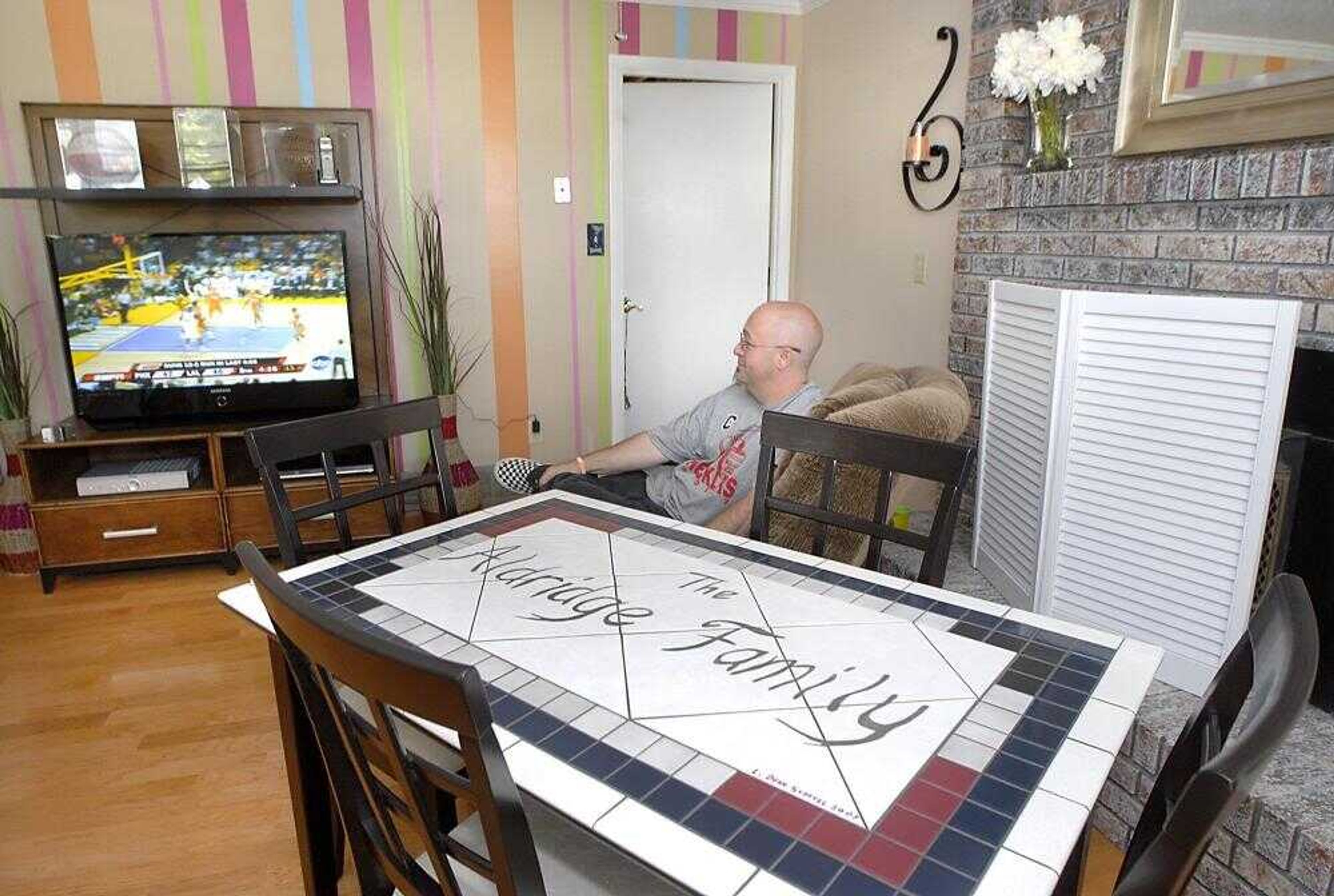 Shannon Aldridge watched television Sunday in the completed sports-themed family room that was made over for his daughter, Sahara, over the weekend by volunteers through the Make-A-Wish Foundation. (Fred Lynch)