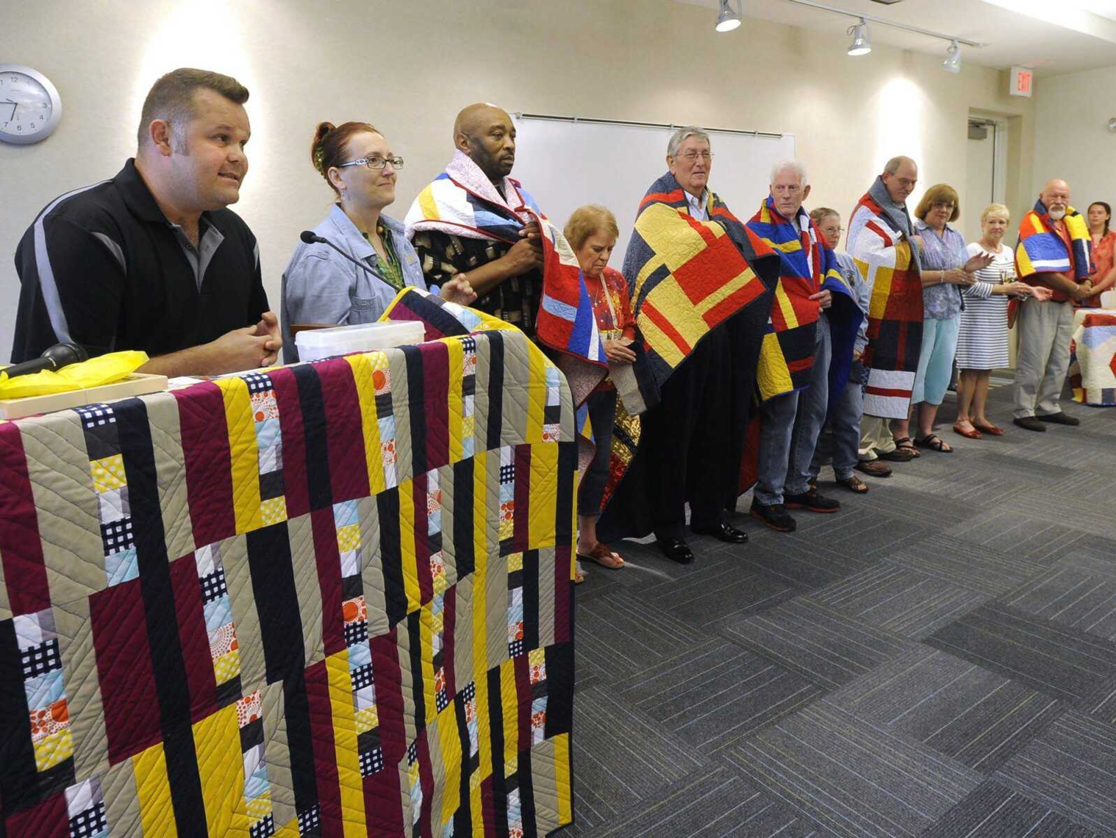 Kevin Huffman, known as &#8220;Kevin the Quilter,&#8221; presents Quilts of Valor to military veterans Terry Simms of Cape Girardeau, Robert Wills of St. Louis, Lawrence Tucker of Jackson, Kenneth Rushton of Poplar Bluff, Missouri, and Johnny Gast of Jackson on Monday during a meeting of the River Heritage Quilt Guild at the Cape Girardeau Public Library. (Fred Lynch)