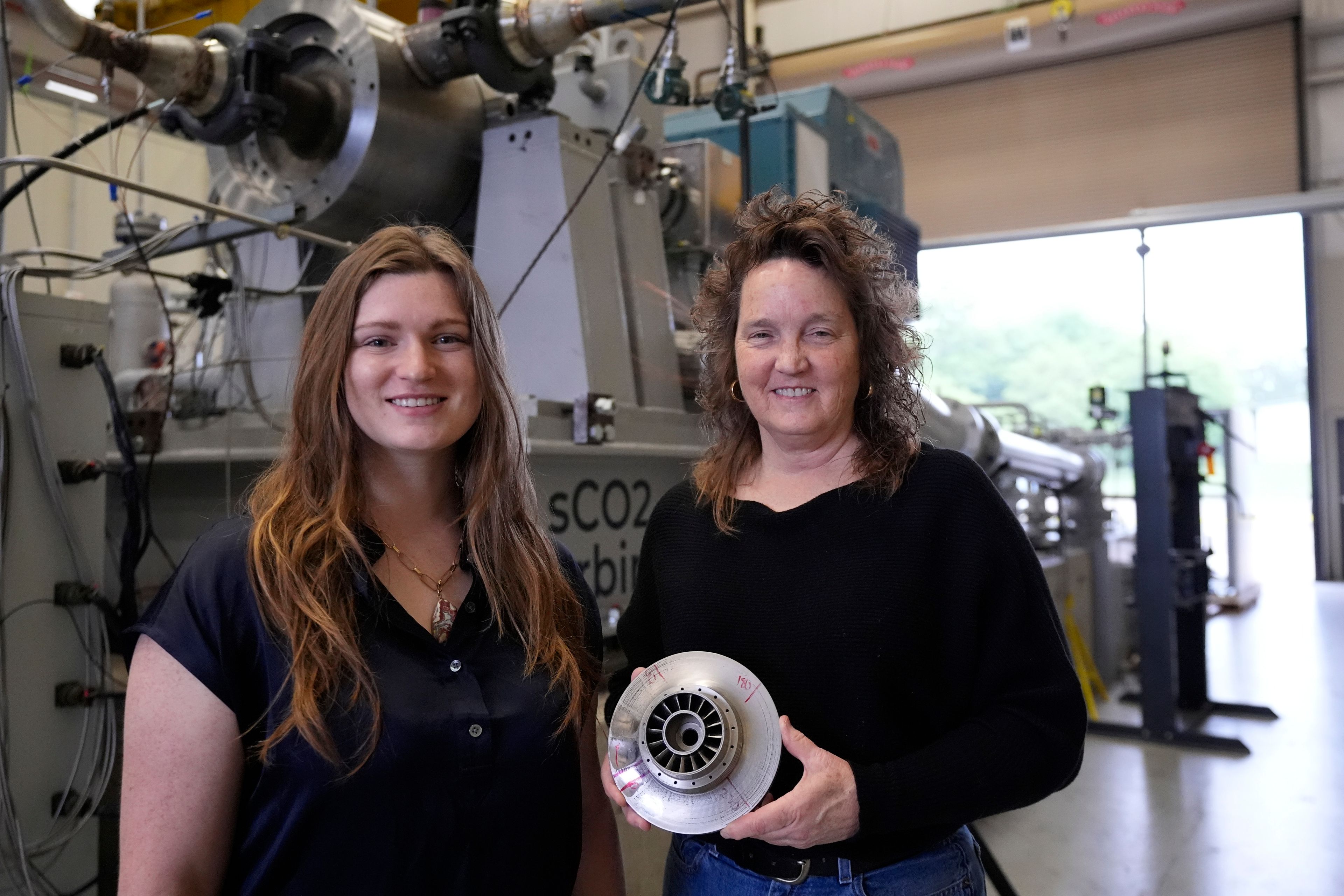 Cindy Taff, right, and Brianna Byrd, left, with Sage Geosystems, a startup that aims to make clean electricity, pose while visiting Southwest Research Institute where testing and research is taking place in San Antonio, Monday, April 1, 2024. (AP Photo/Eric Gay)