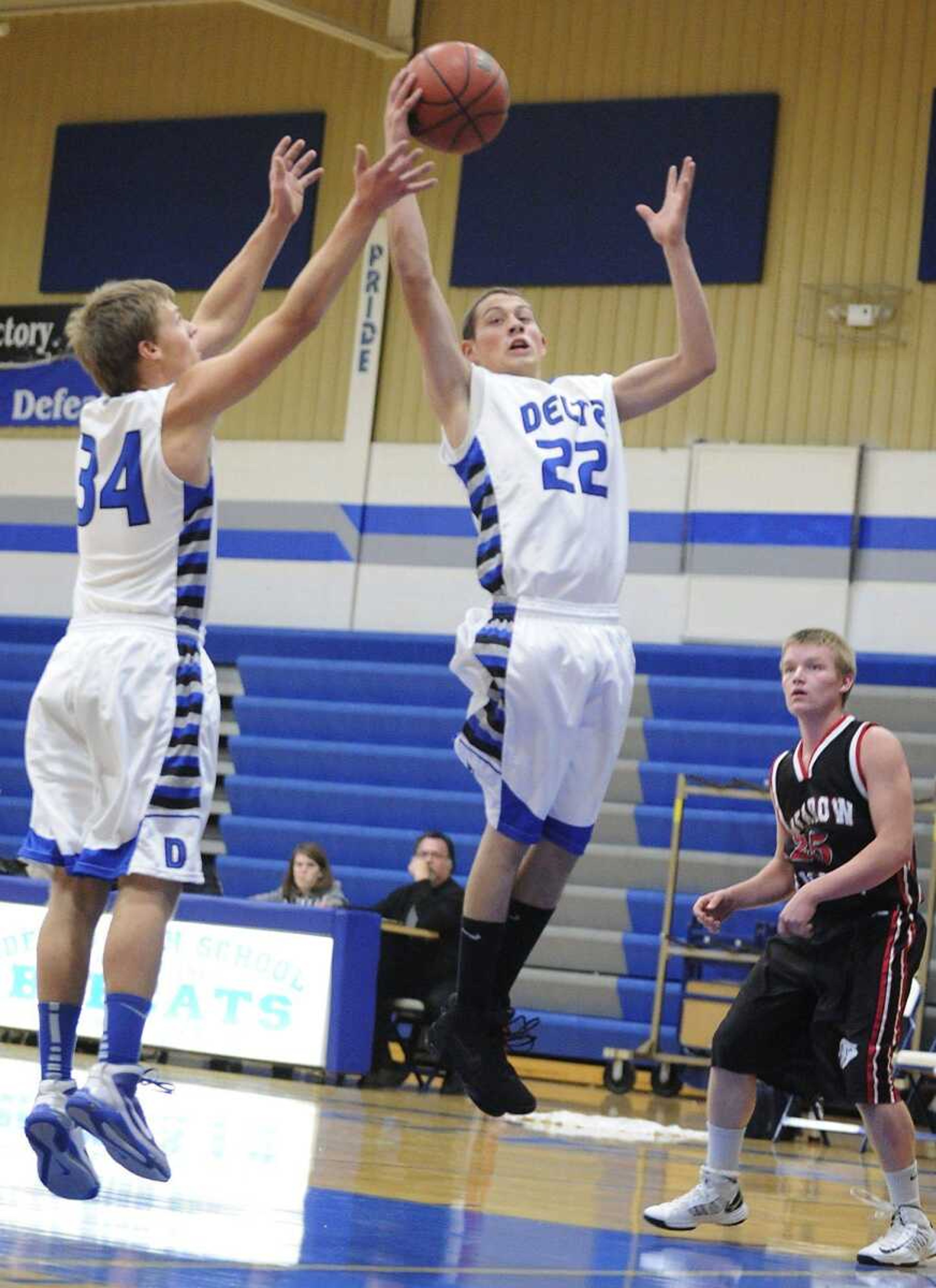 Delta's Tanner Schabbing, middle, grabs a rebound during the Bobcats' overtime loss to the Meadow Heights Panthers Tuesday, Dec. 11, at Delta High School. (ADAM VOGLER)