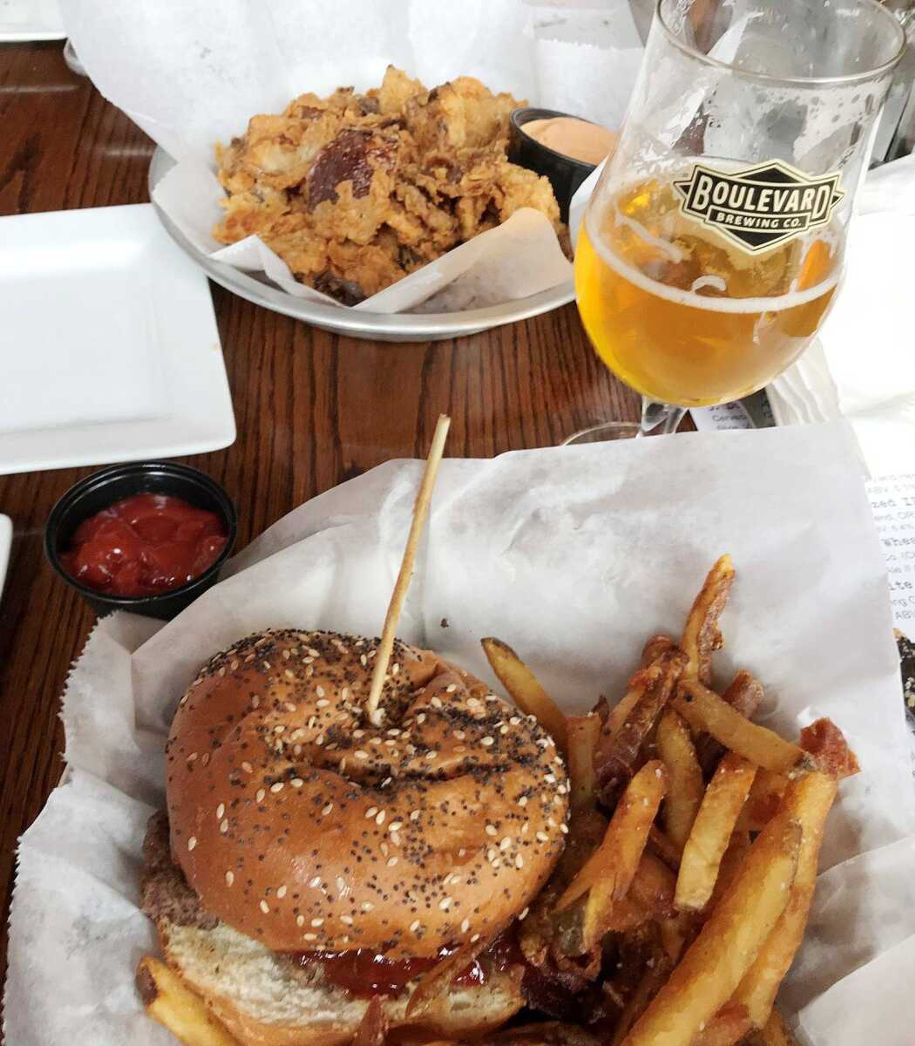 Dining at Mary Jane's: PB-QUE burger with fries, house-made ketchup, a side of onion petals and a Tank 7 to drink.