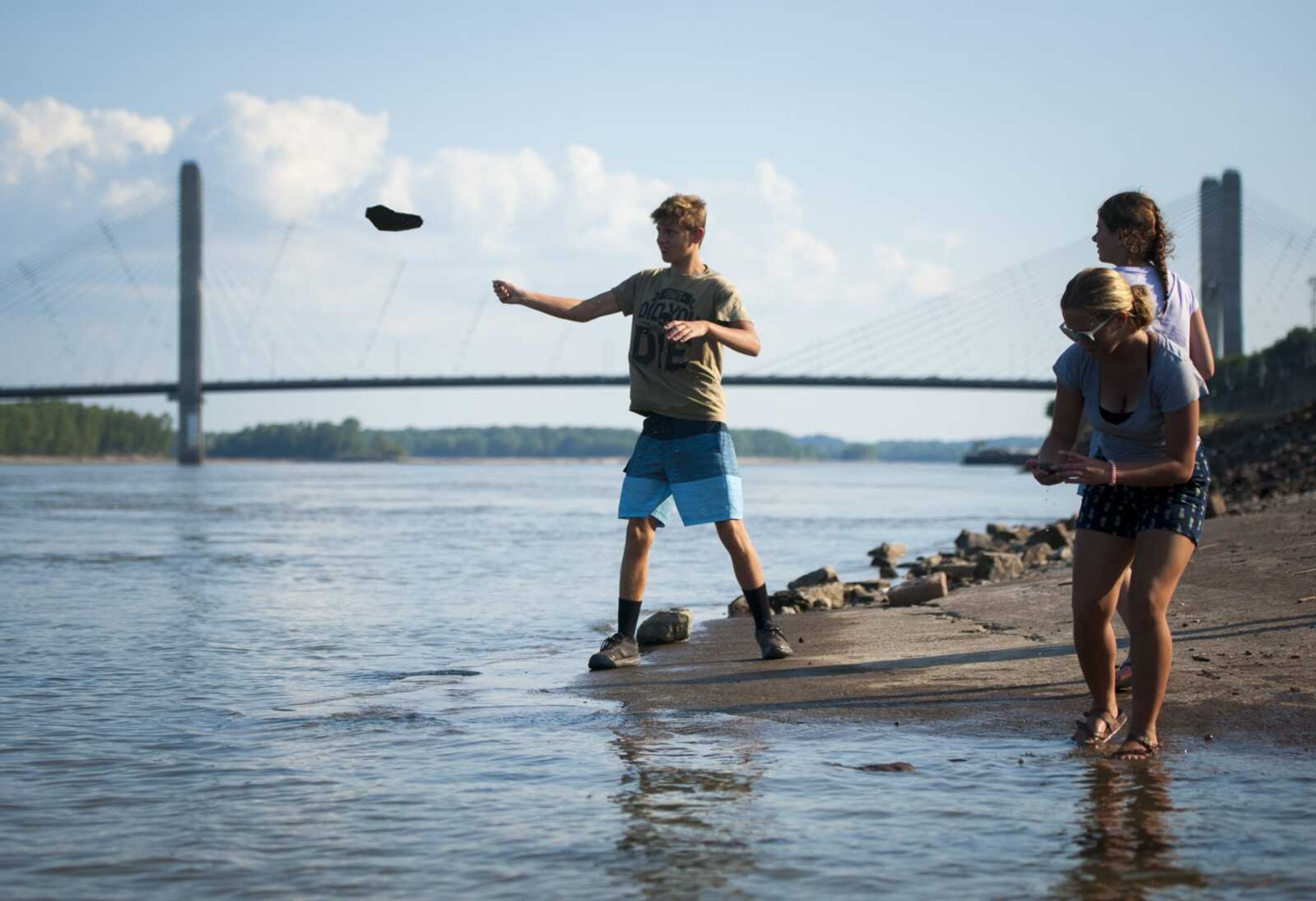 After a day at Cape Splash Family Aquatic Center, 16-year-old Jacob Yount of Marquand, Missouri, throws rocks into the Mississippi River with his 12-year-old sister Jaden, above right, and Nevaya Whitener on Sunday at Riverfront Park in Cape Girardeau. The day marked the children's last day of summer vacation before returning to school in the upcoming week.