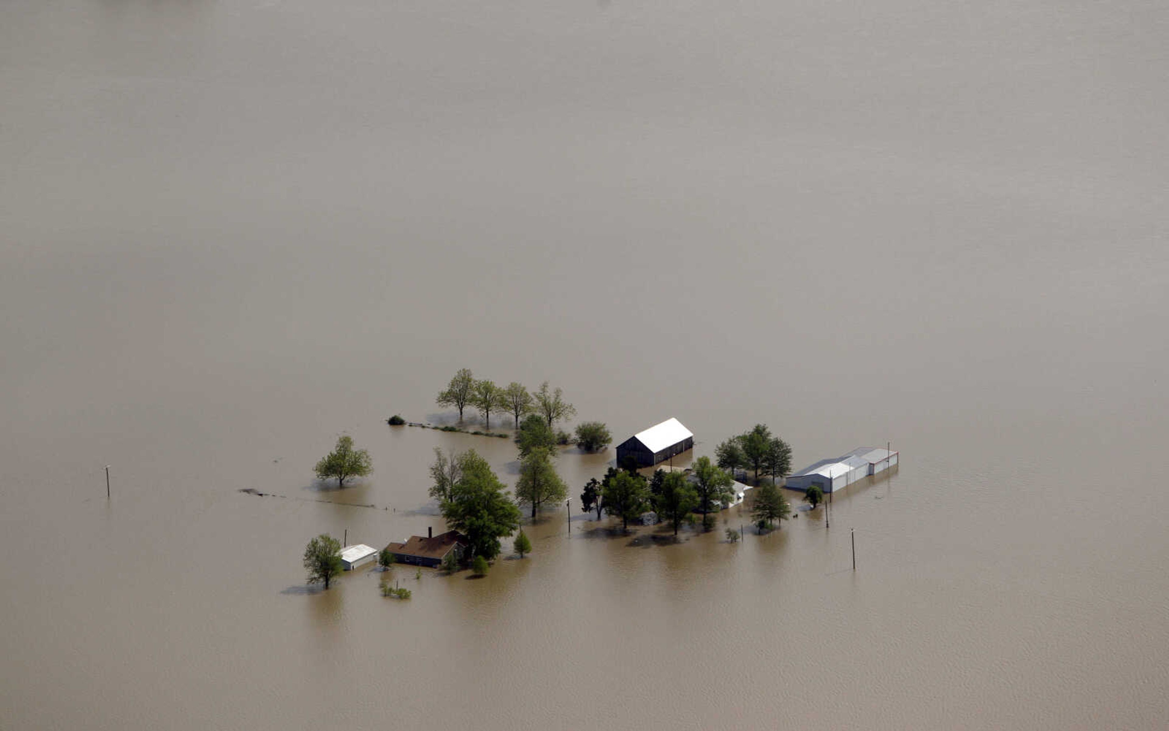 Buildings are seen surrounded by floodwater Tuesday, May 3, 2011, in Mississippi County, Mo. The Army Corps of Engineers blew a two-mile hole into the Birds Point levee in southeast Missouri, flooding 130,000 acres of farmland in Missouri's Mississippi County in an effort to protect nearby Cairo, Ill. (AP Photo/Jeff Roberson)