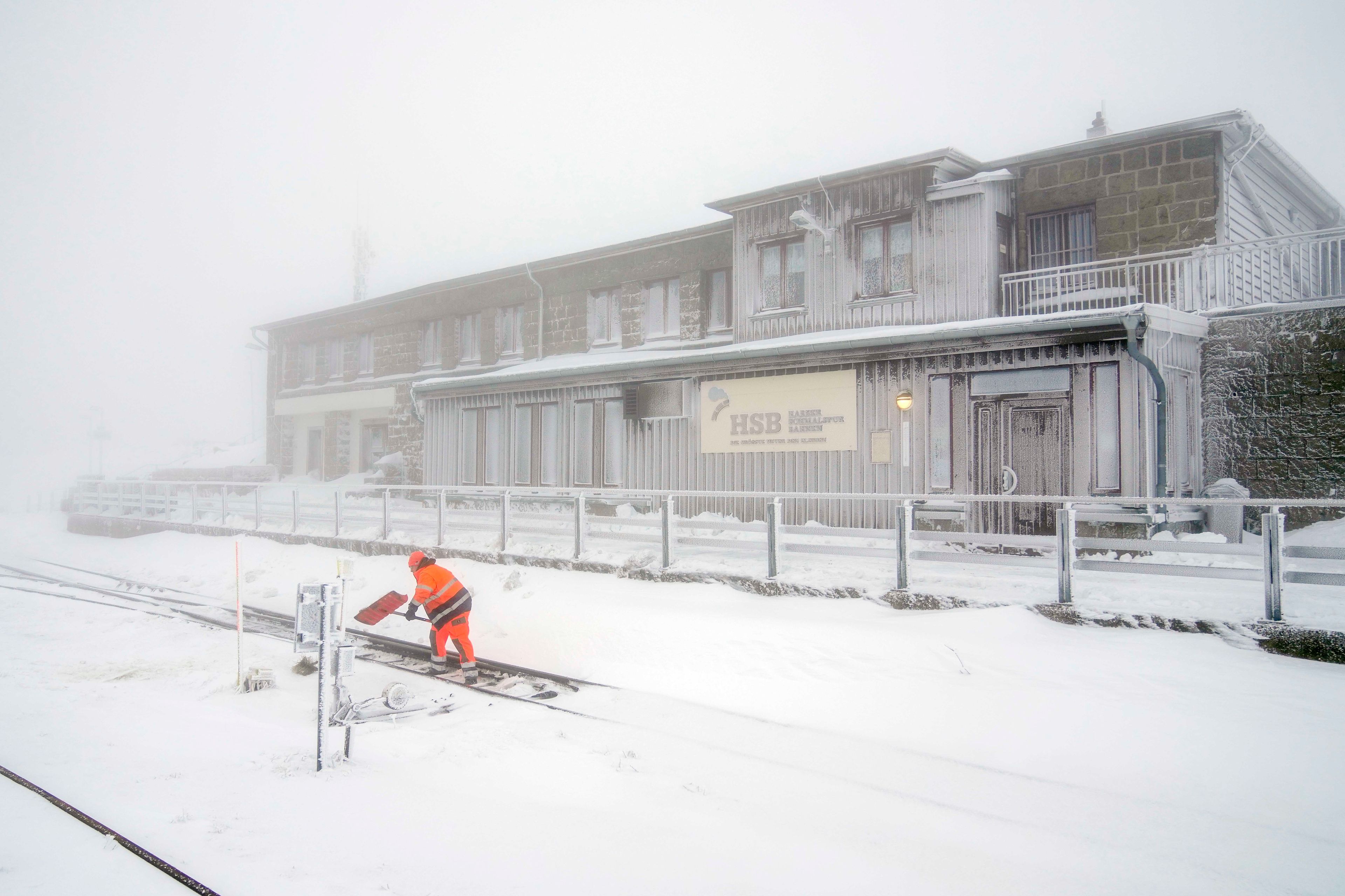 A railroad worker clears the tracks of snow on northern Germany's 1,142-meter (3,743 feet) highest mountain 'Brocken' at the Harz mountains near Schierke, Germany, Wednesday, Nov. 20, 2024. (AP Photo/Matthias Schrader)