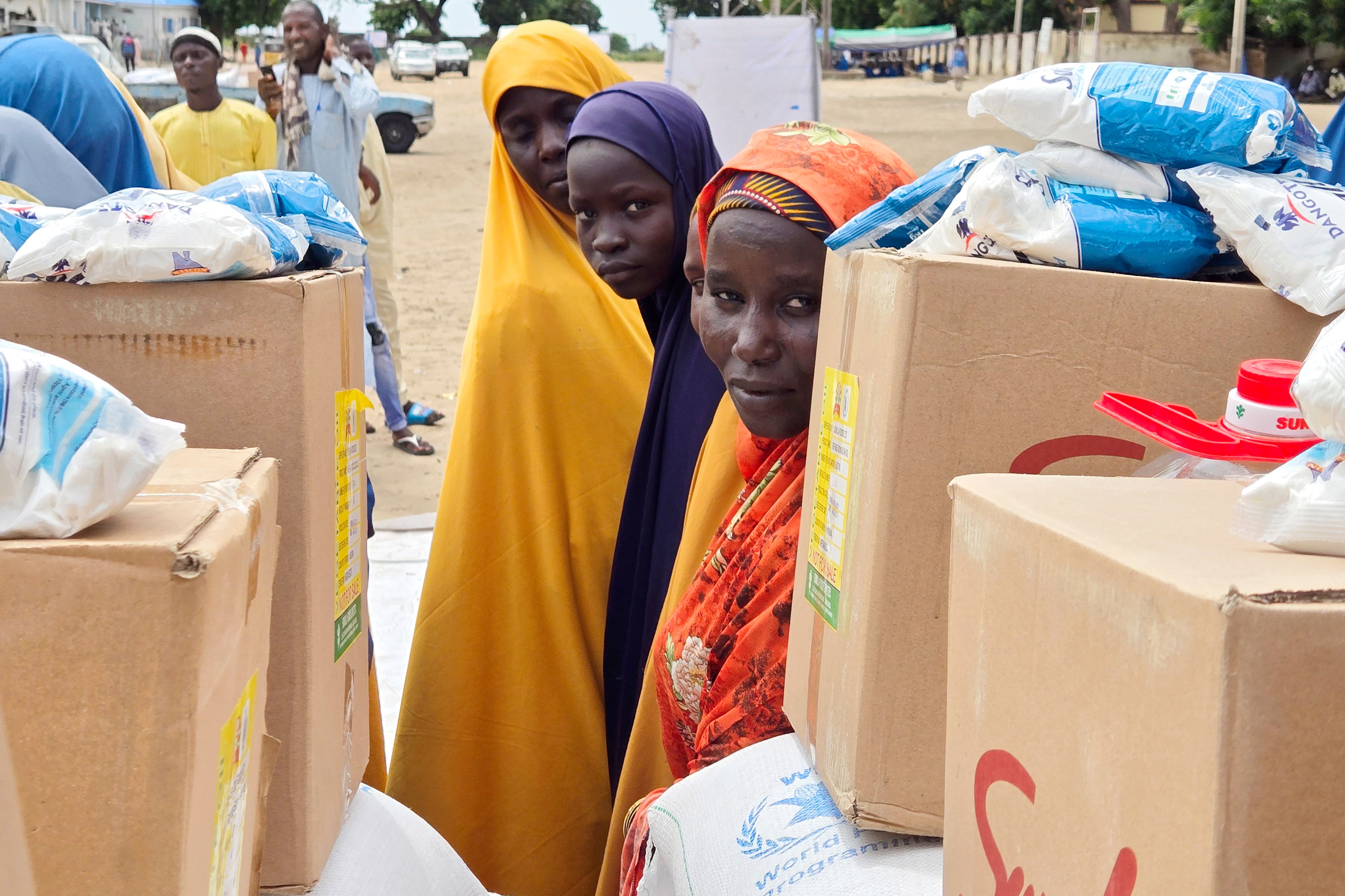 Women and villagers wait to receive food donations from the United Nations World Food Program in Damasak, northeastern Nigeria, Sunday, Oct. 6, 2024. (AP Photo/Chinedu Asadu)