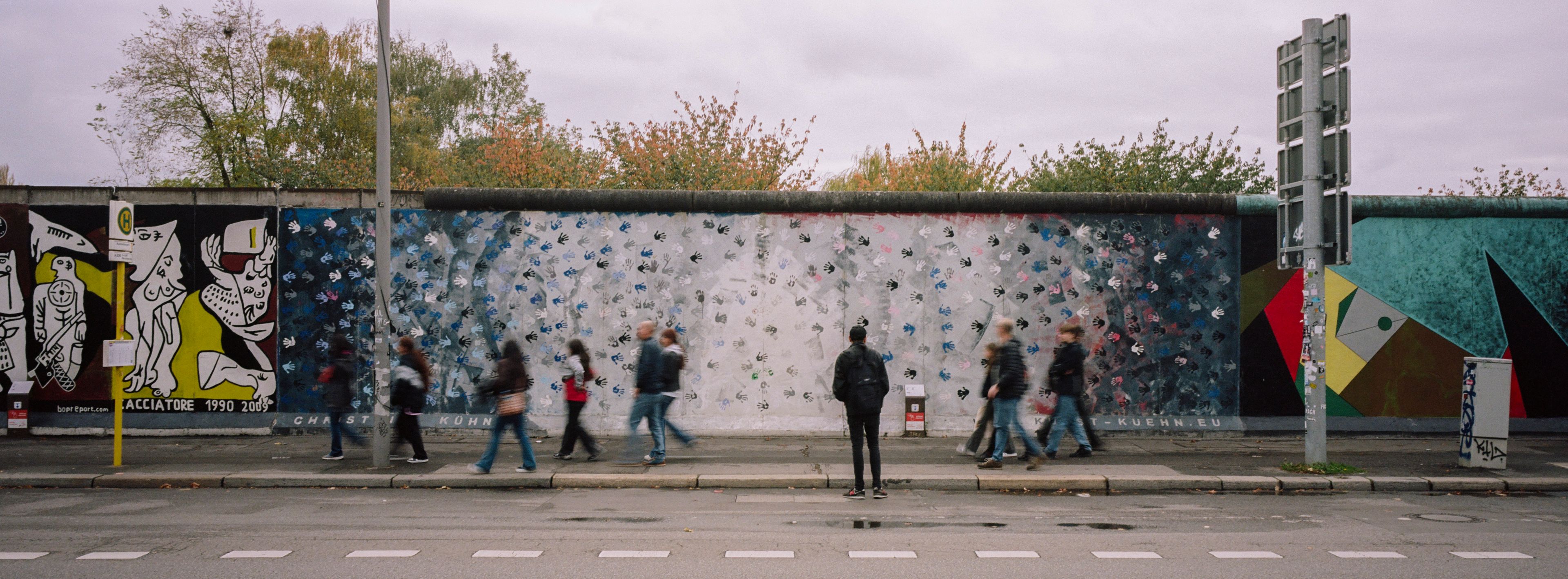 People gather at a painting at the so-called East Side Gallery, a popular place for street art on remains of the Berlin Wall in Berlin, Germany, Wednesday, Oct. 30, 2024. (AP Photo/Markus Schreiber)