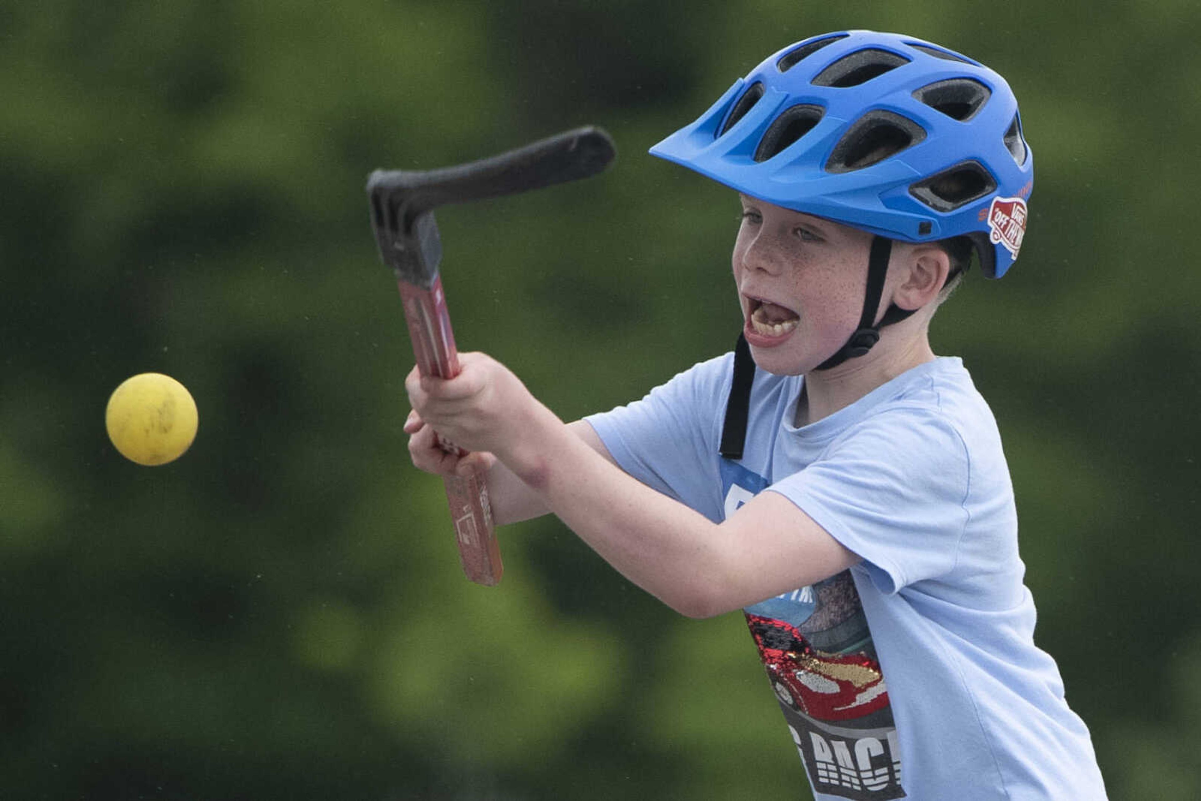 Henri Booch, 7, handles a ball while playing hockey with family Wednesday, May 20, 2020, at a parking lot near Cape Splash Family Aquatic Center in Cape Girardeau.