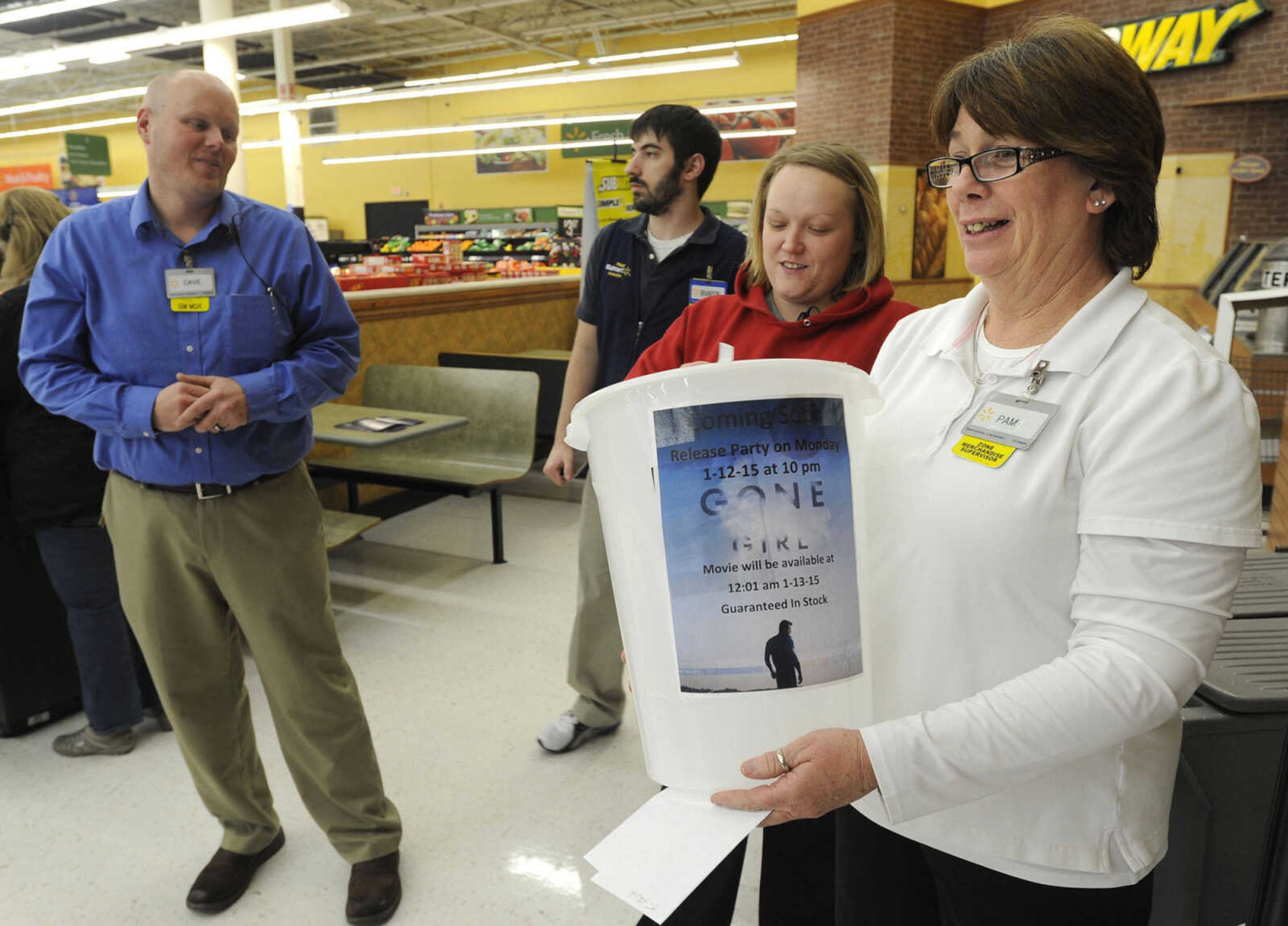 Pam Chavez, right, and Renee Fischer draw names from the trivia contest for prizes at the "Gone Girl" DVD release party Monday, Jan. 12, 2015 at Walmart in Cape Girardeau. Shift manager Dave Avery, left, conducted the contest.