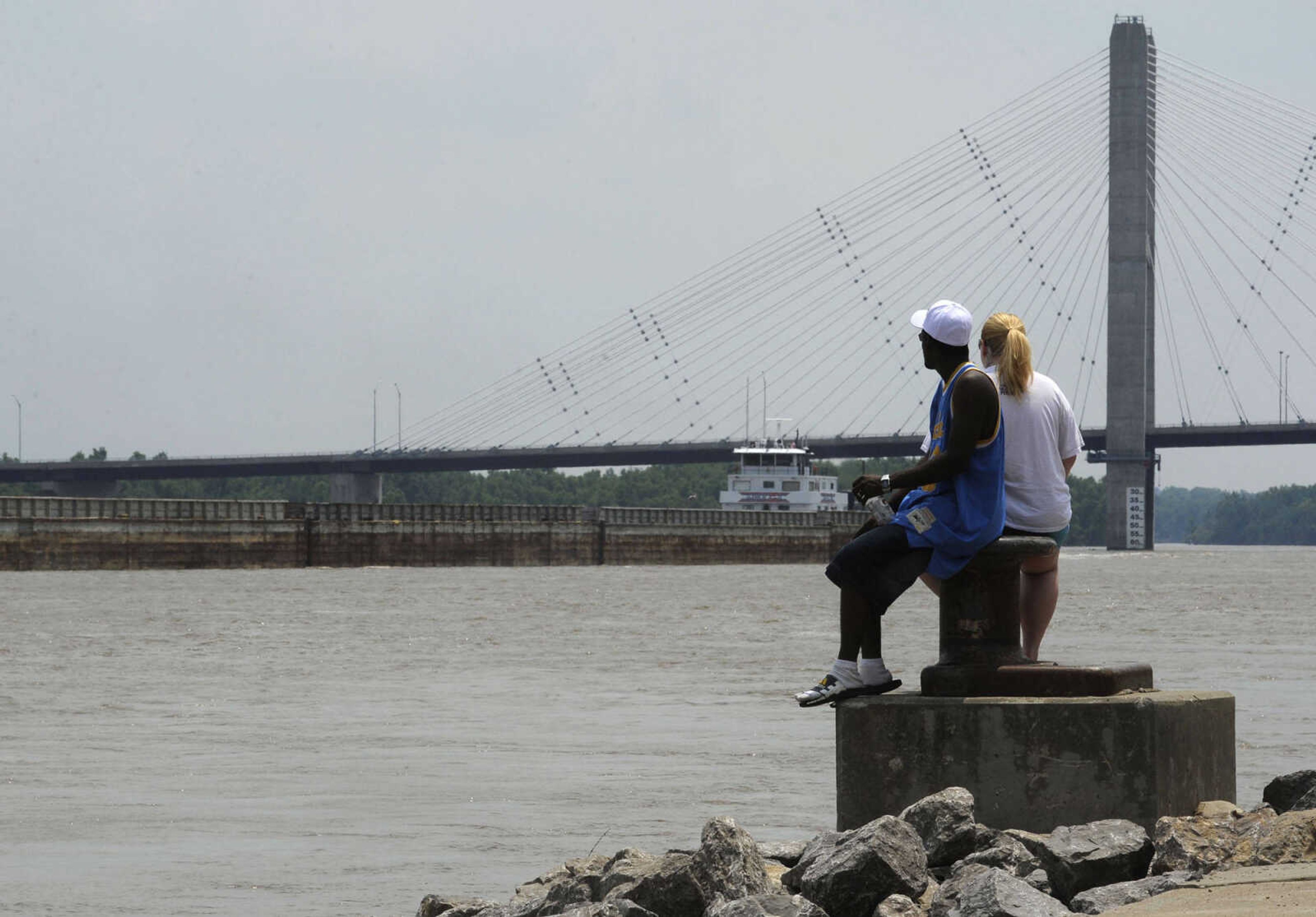 Visitors at the Cape Girardeau riverfront watch barges going up the Mississippi River on Sunday, June 23, 2013. The river stage had dropped below 34 feet on the river gauge, with flood stage at 32 feet.