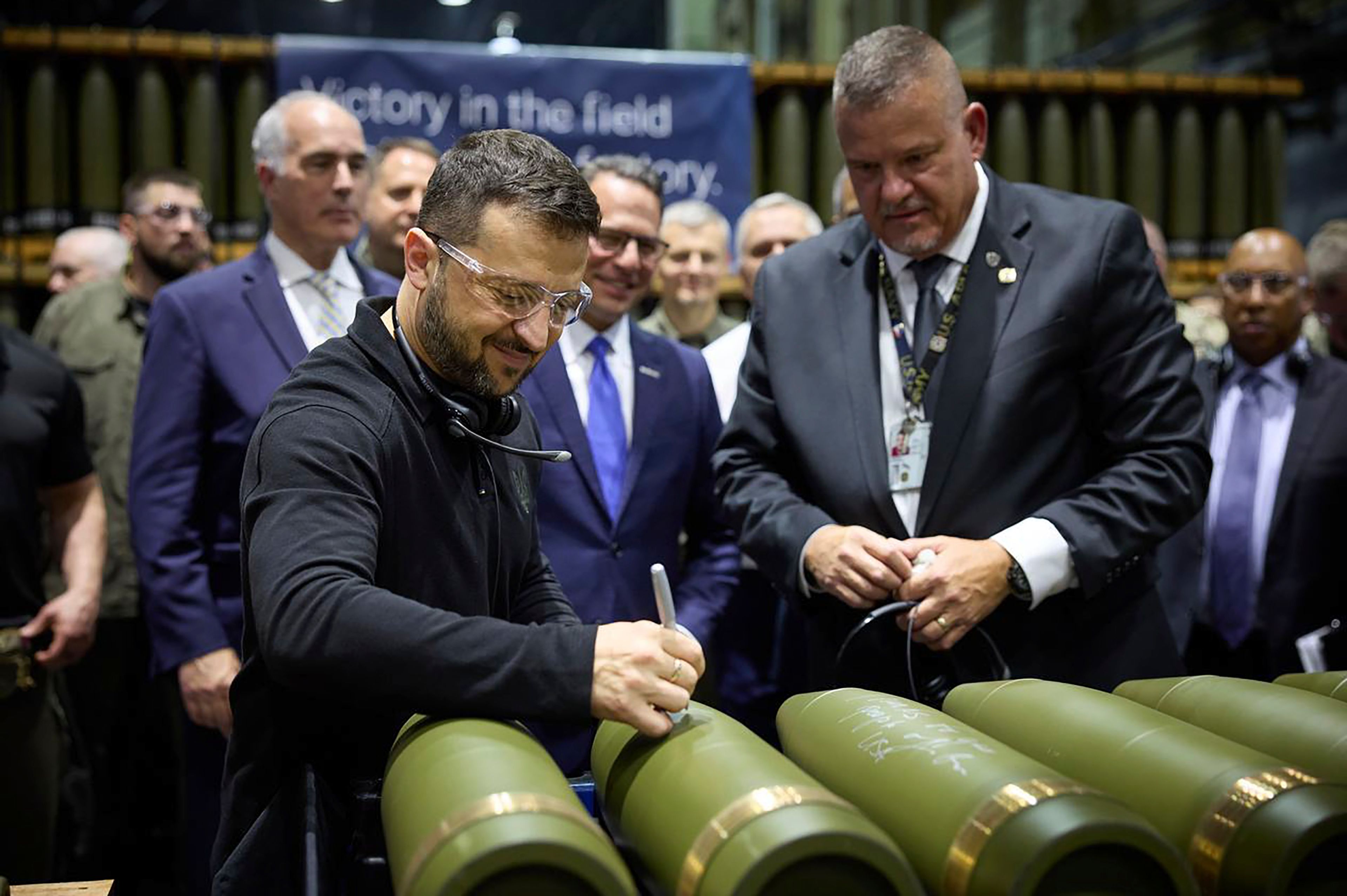 FILE - In this image provided by the Office of the Ukrainian Presidency, Ukrainian President Volodymyr Zelenskyy, left, is watched by Rich Hansen, the commander's representative for the Scranton Army Ammunition Plant, while signing military ordnance in Scranton, Pa., Sunday, Sept. 22, 2024. (Office of the Ukrainian Presidency via AP, File)