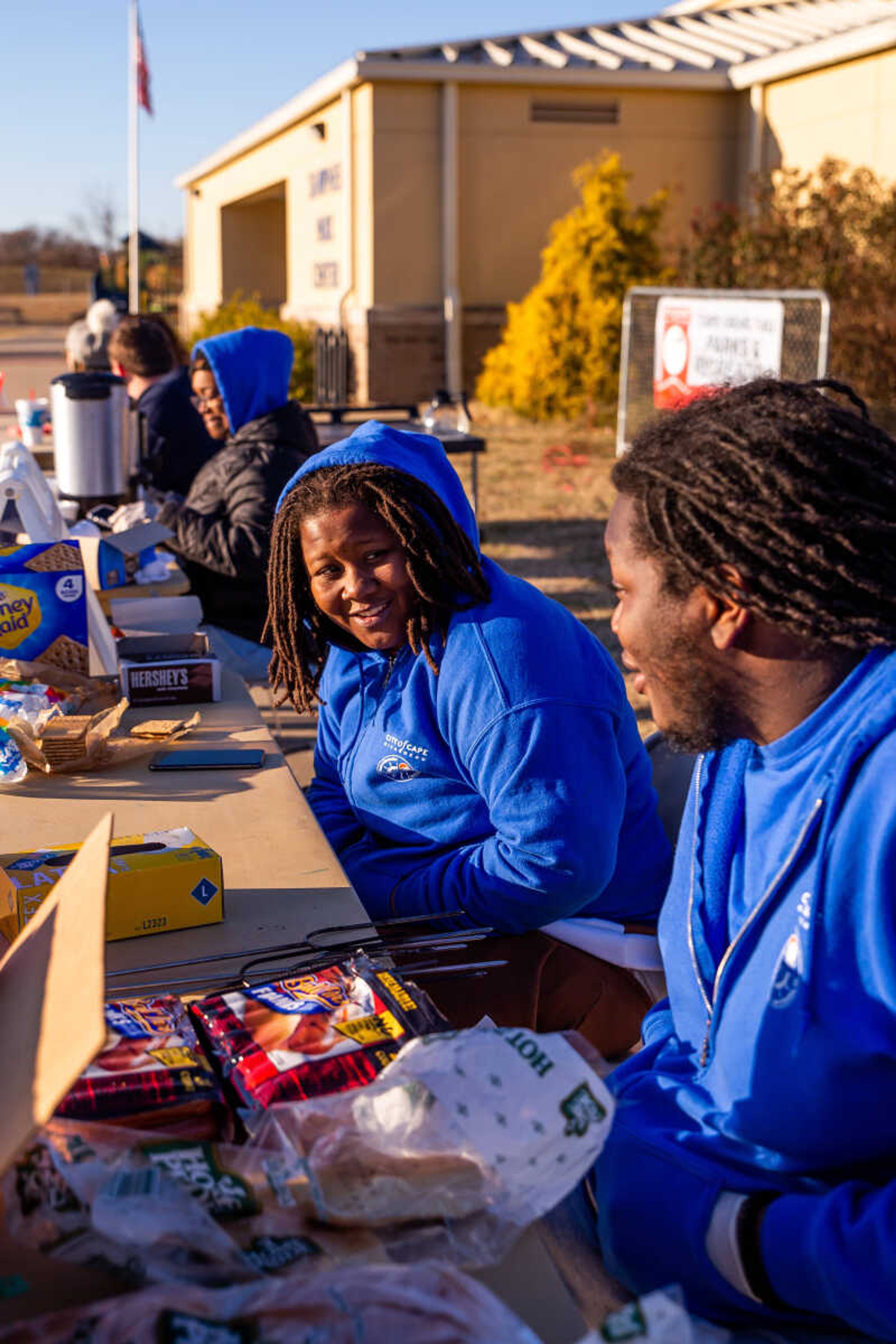 Shawnee Center employee  Yienvi Johnson speaks with a fellow employee while giving out s'more ingredients at the on Sunday, Nov. 20 at the Fall Family Festival.