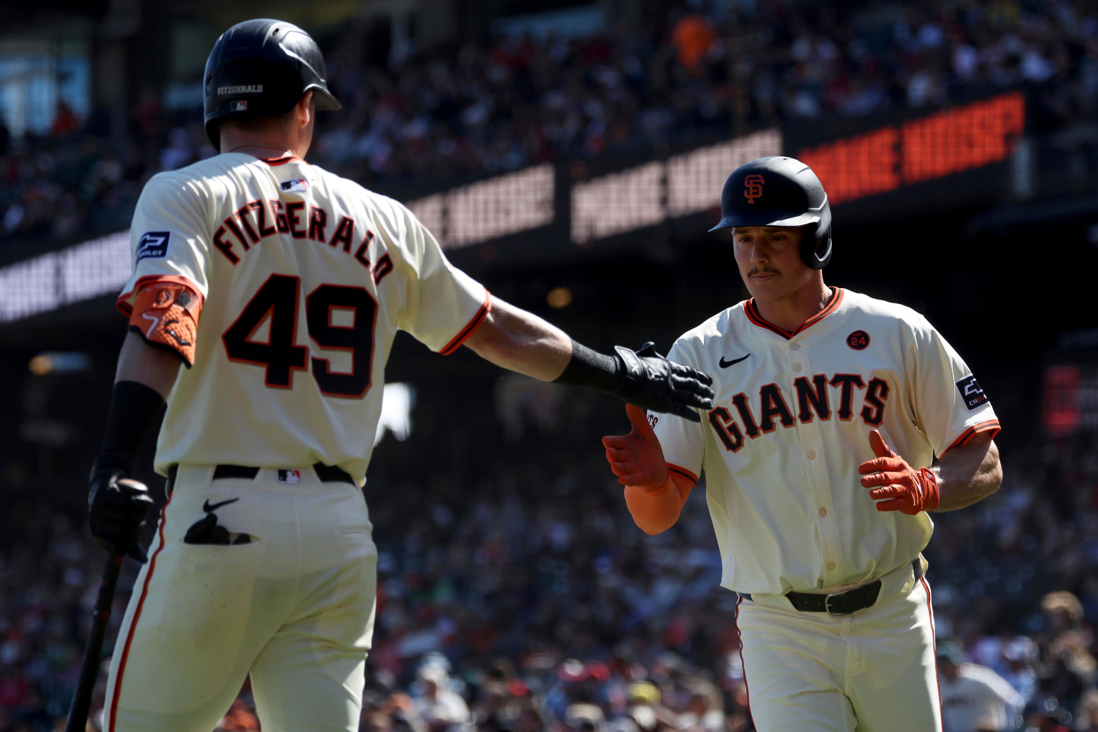 San Francisco Giants' Matt Chapman, right, is congratulated by Tyler Fitzgerald after scoring on a single by Patrick Bailey (49) during the fourth inning of a baseball game against the St. Louis Cardinals in San Francisco, Saturday, Sept. 28, 2024. (AP Photo/Jed Jacobsohn)